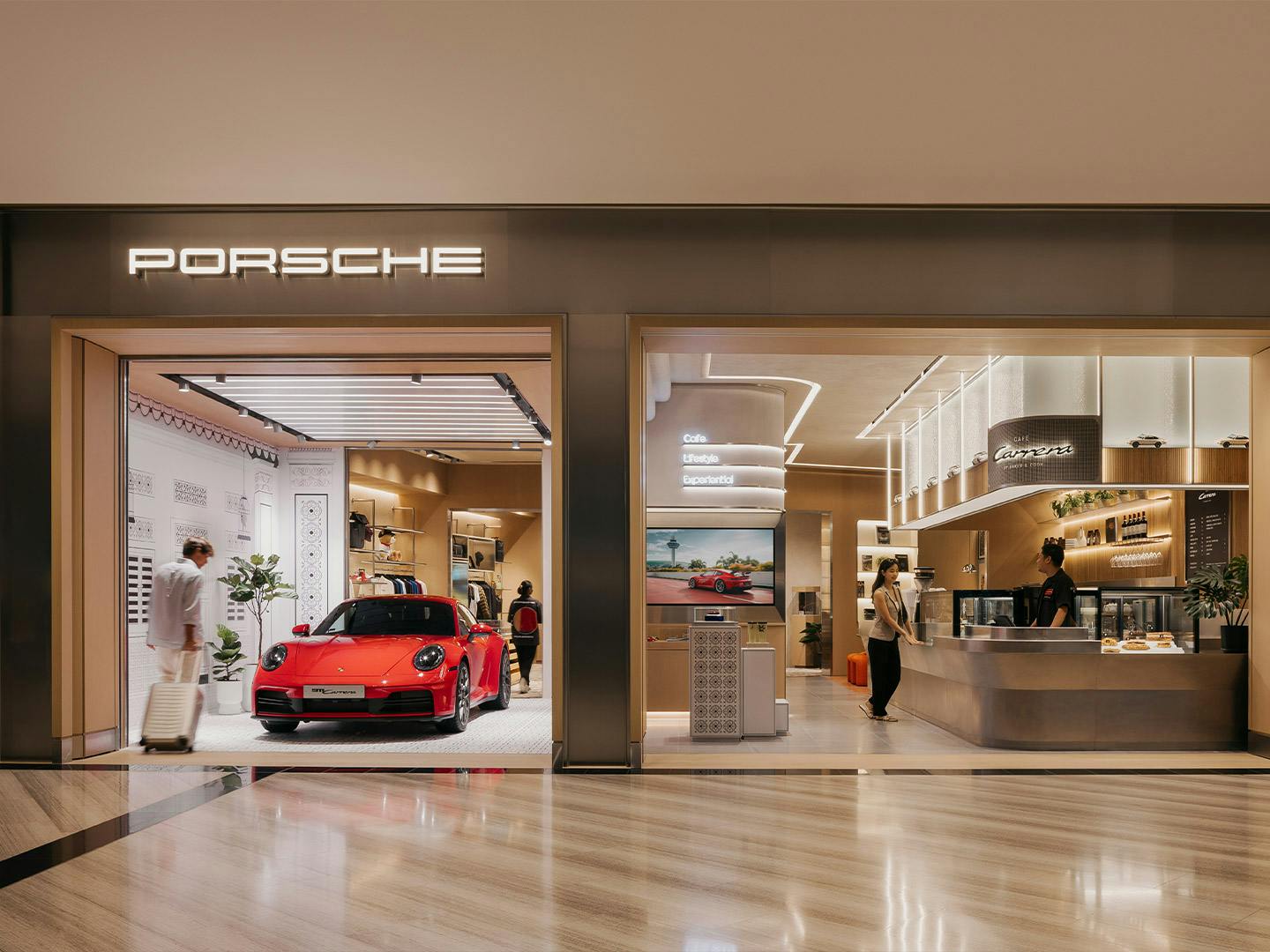 Airport in Singapore with a red 911 Carrera displayed in showroom and Café Carrera coffee bar visible through glass storefront.