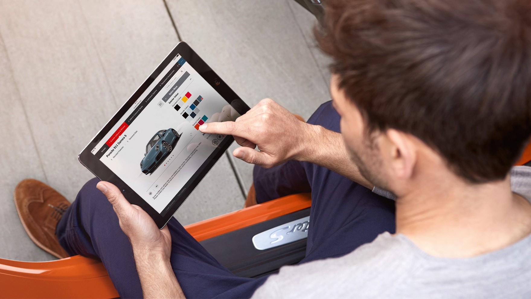 A man looking into cars in Finder webpage In a tablet.