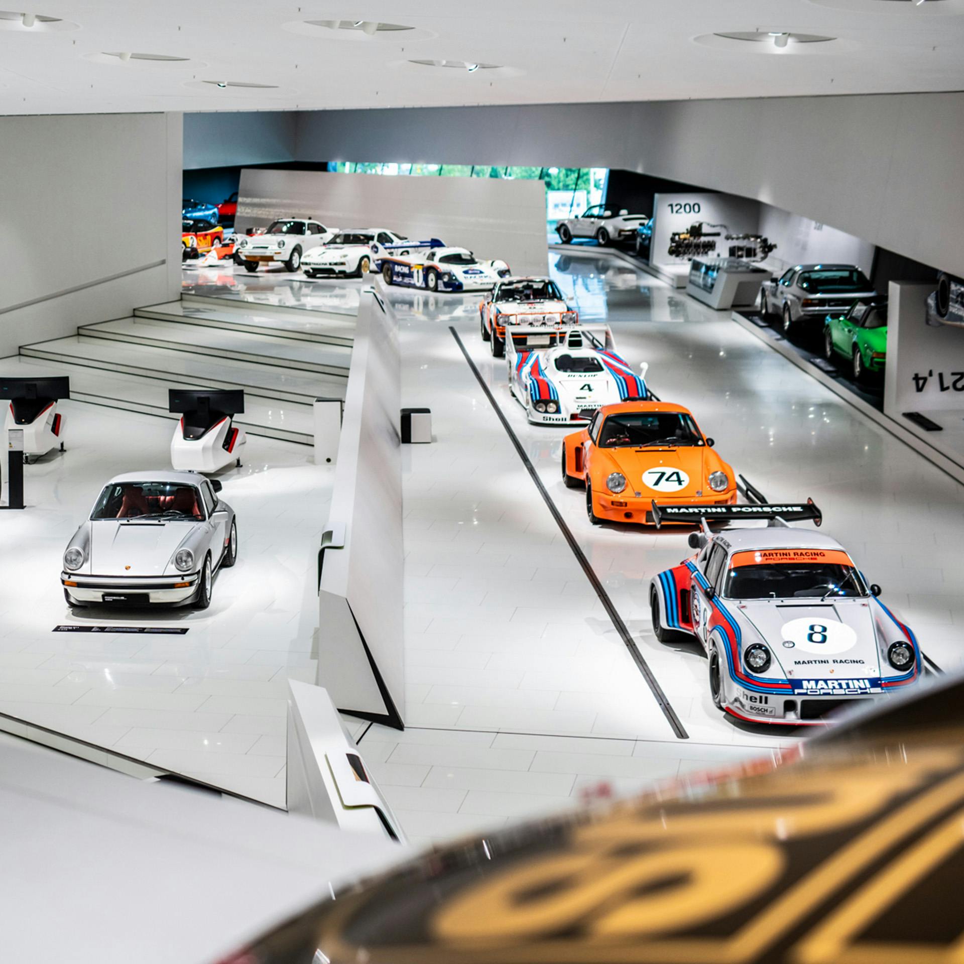 Interior view of the Porsche Museum with several exhibited Porsche cars