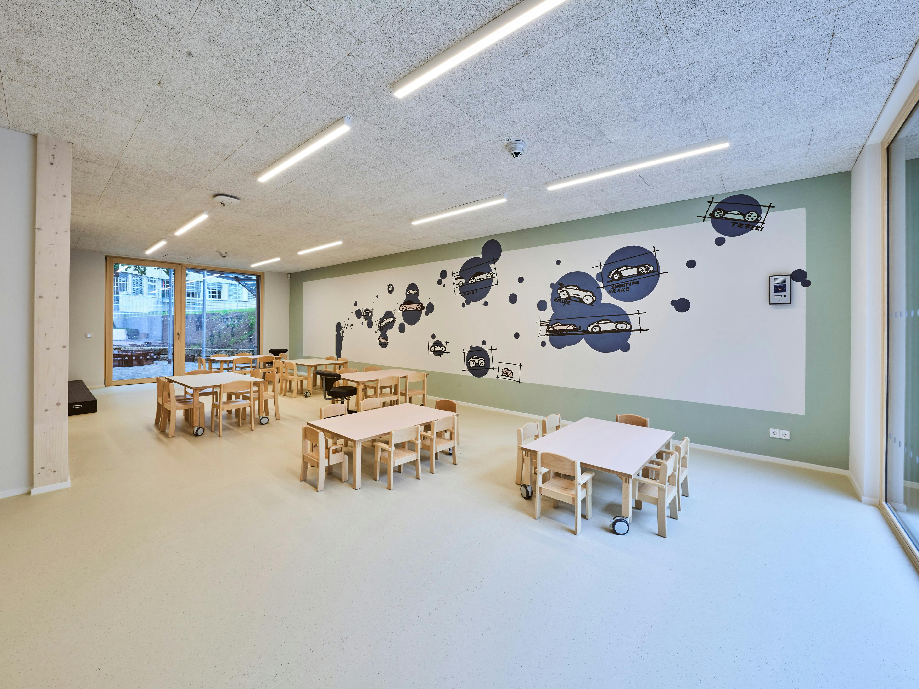 Der Aufenthaltsraum in der Porsche Kindertagesstätte ist hell, modern und kindergerecht gestaltet.