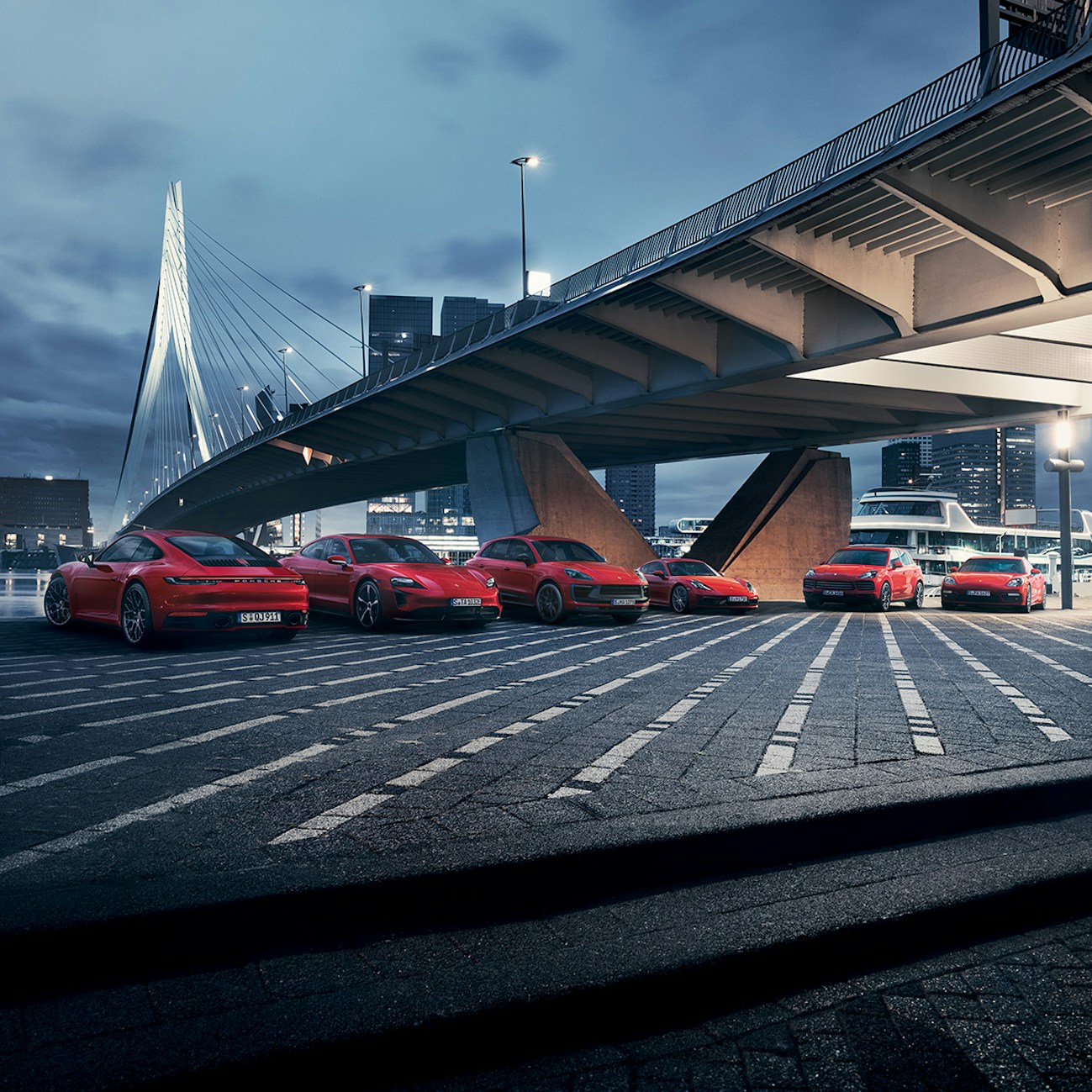 Mehrere Porsche-Autos auf der Straße, vor einer Brücke
