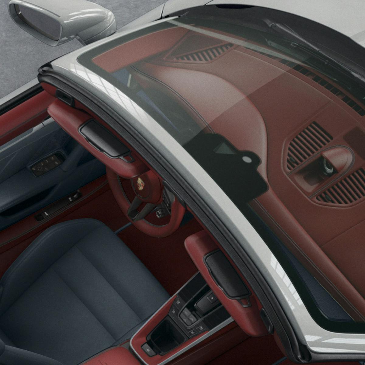 Interior view of a Porsche with a red dashboard, blue seats, and visible windshield details, showcasing luxury design and craftsmanship.
