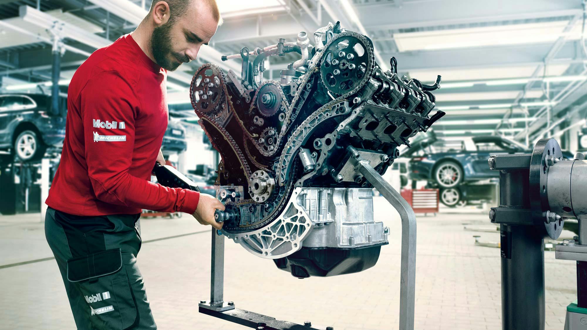 Porsche mechanic servicing an engine.