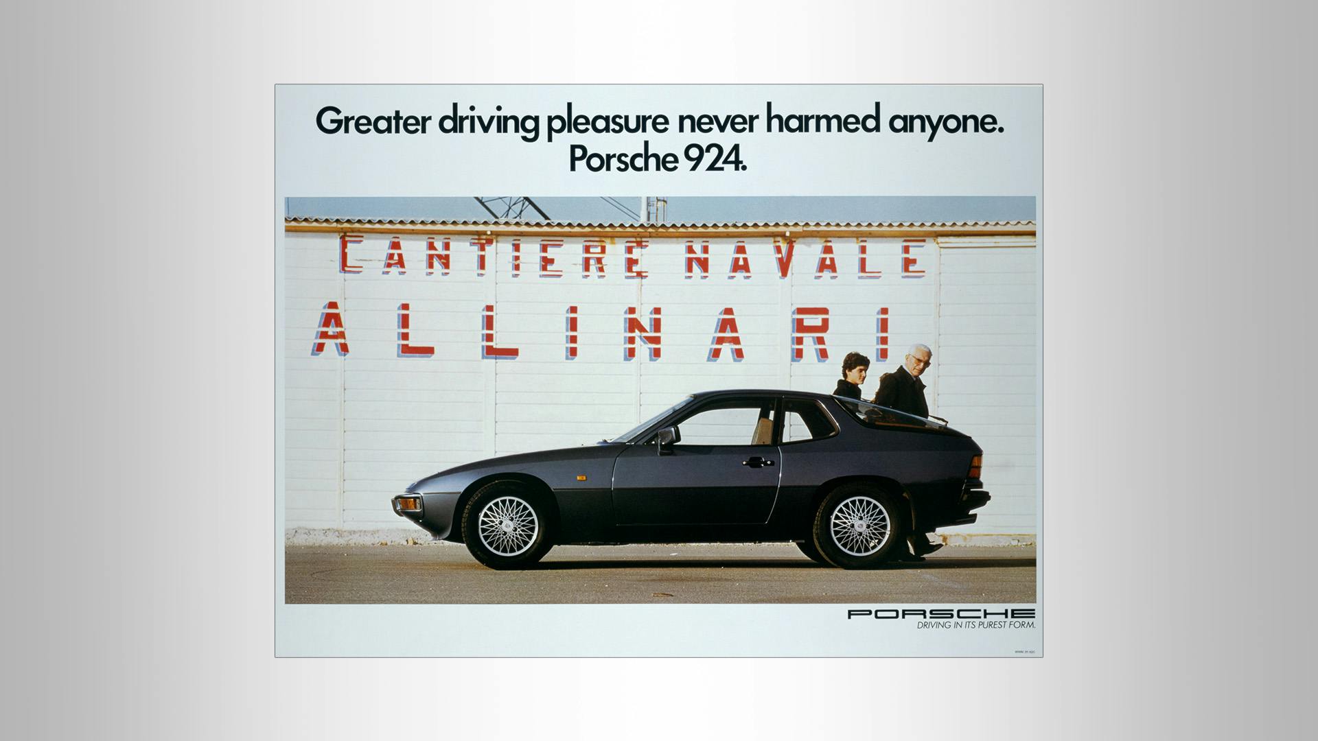 Advertising poster of a Porsche 924 standing in front of a wall with the writing: Greater driving experience never harmed anyone. Porsche 924