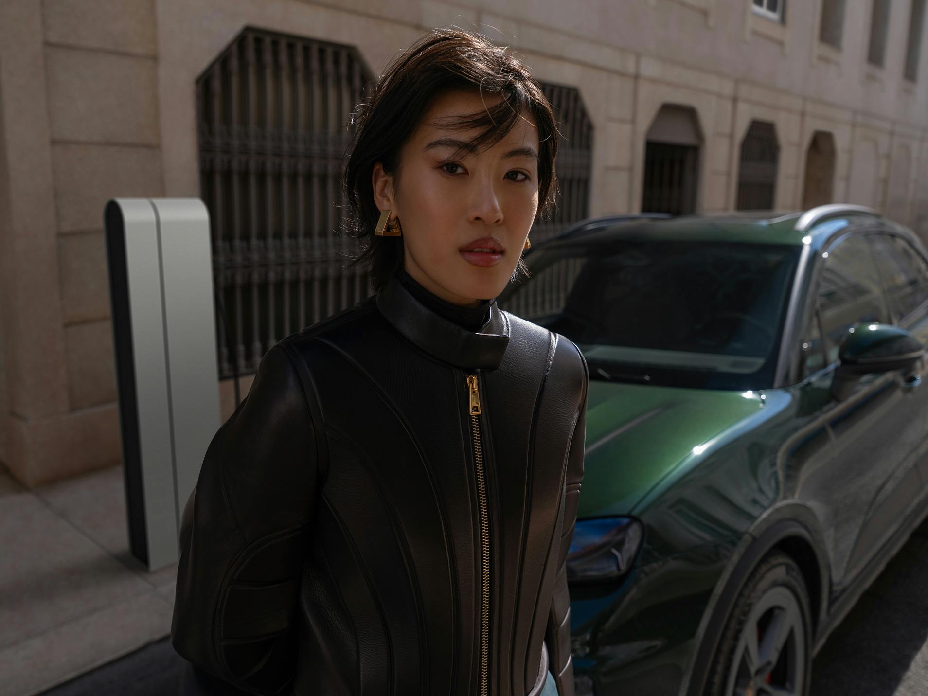 A woman standing in front of a Porsche Macan 4S looking into the camera.