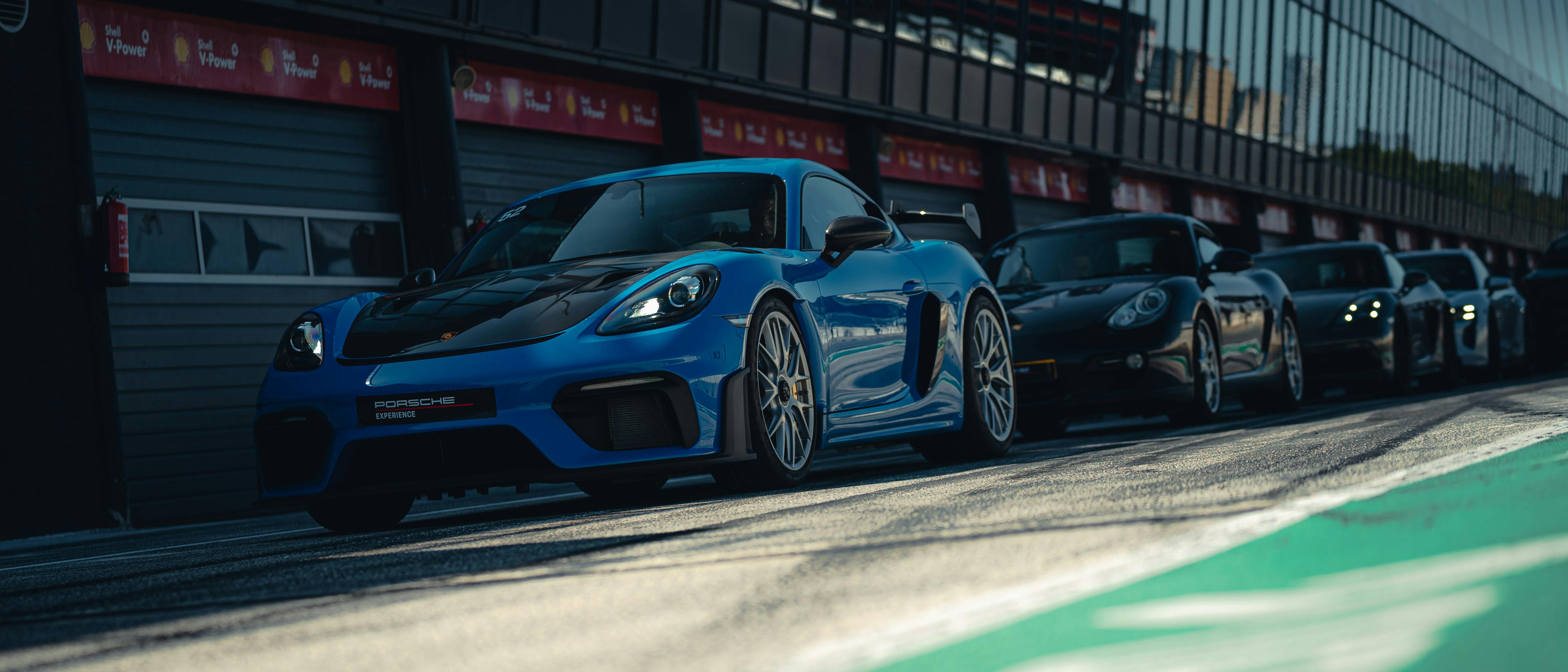 Verschillende Porsche auto's rijden op het circuit tijdens de Porsche Track Experience