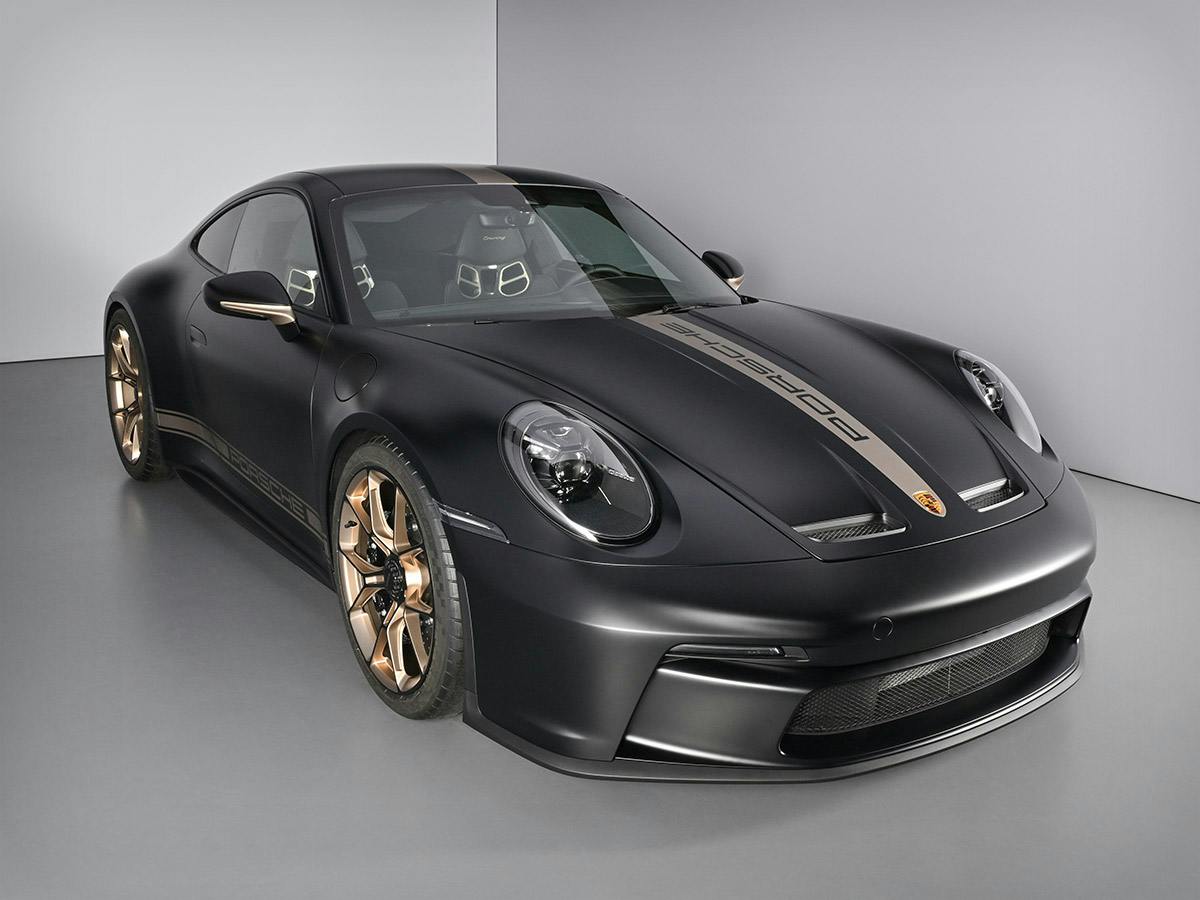 A 911 GT3 with Touring Package in Black Matt with Neodyme accents, photographed from a front three‑quarter angle in a lightbox.