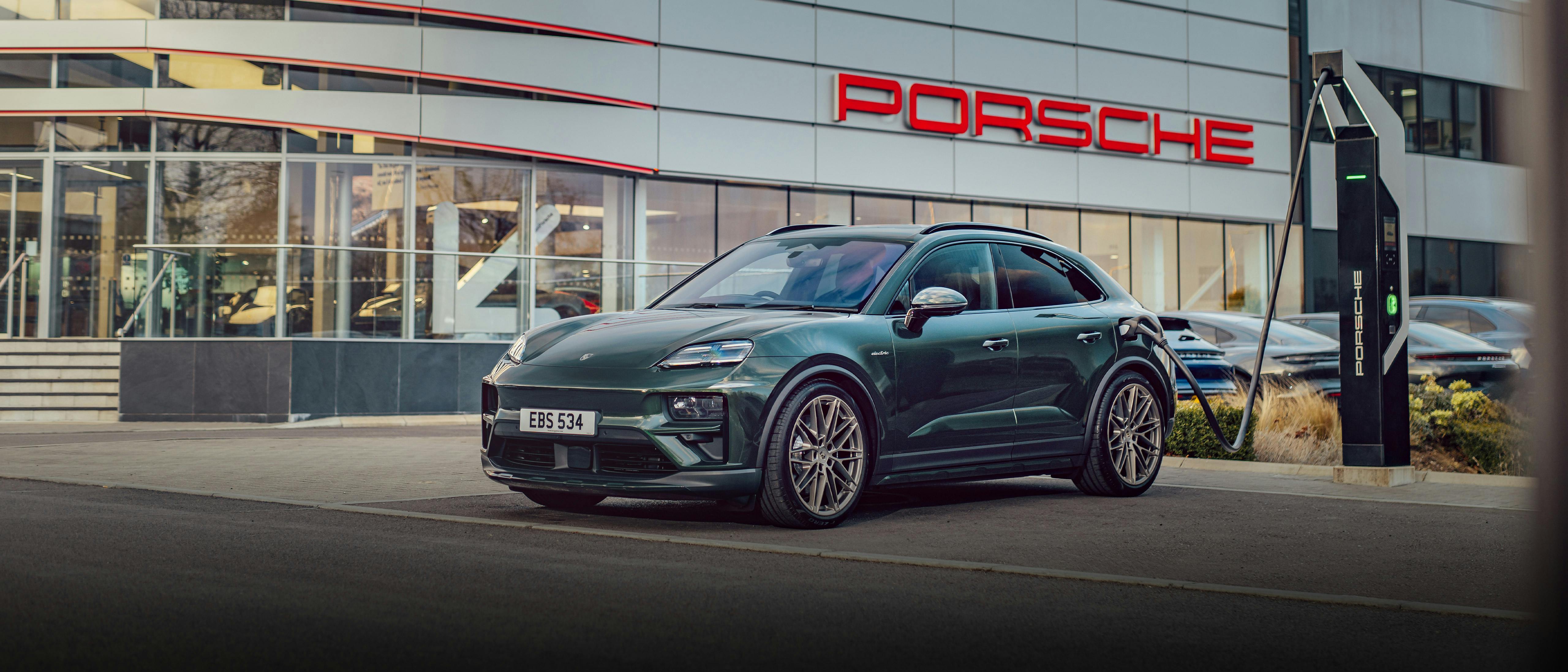 Porsche Macan Electric plugged in charging at Porsche Centre Reading during the day time.