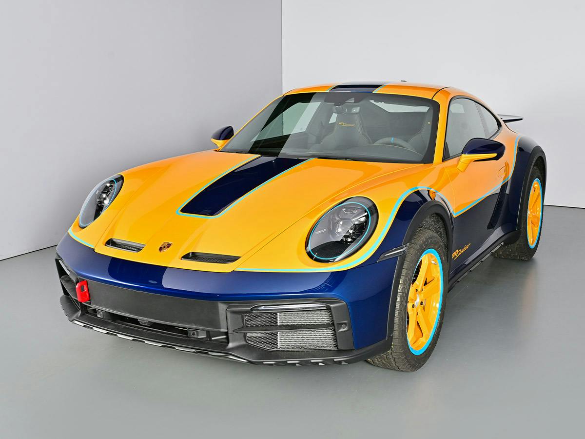 A Porsche 911 Dakar (992) LT Design, shown from the front view, featuring a two-tone finish with Signalyellow upper body and Gentian Blue Metallic lower section.