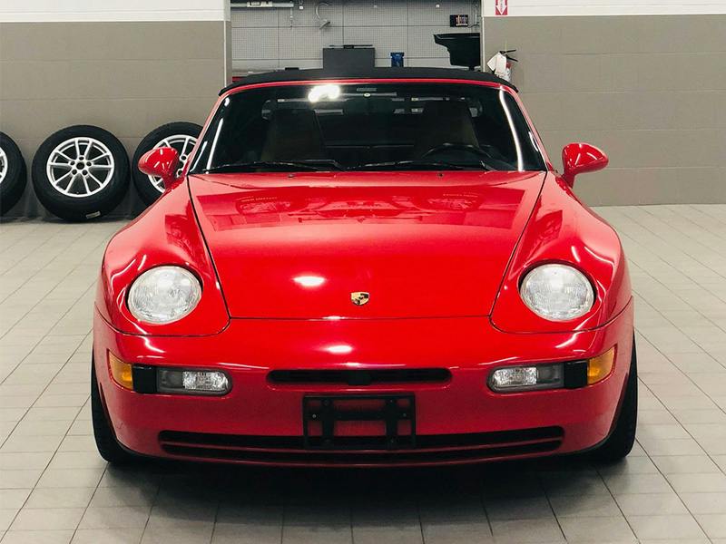 Red 968 convertible in a workshop.
