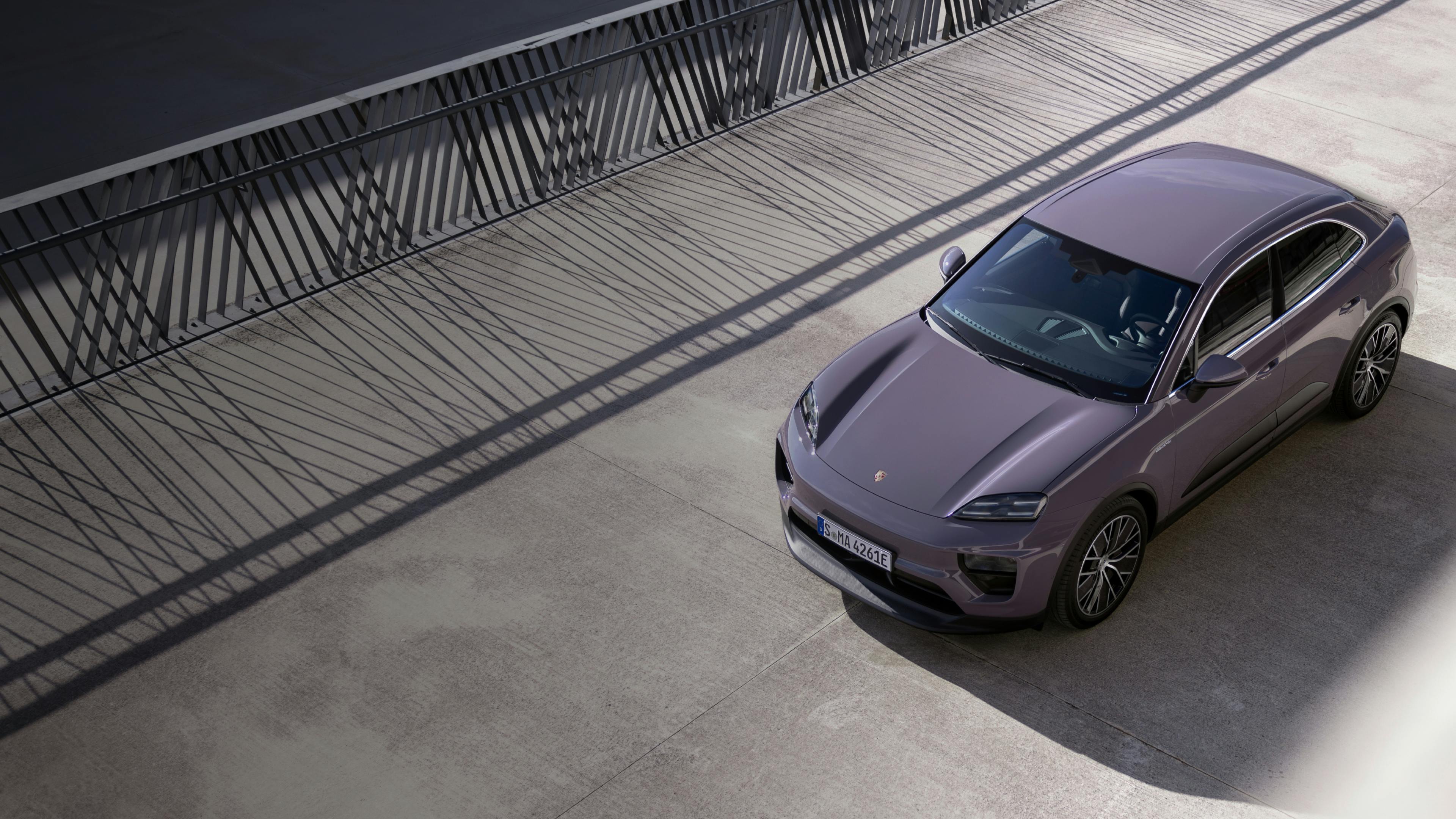 Top view of a Porsche Macan 4 in Provence paint finish in a Grey concrete area.