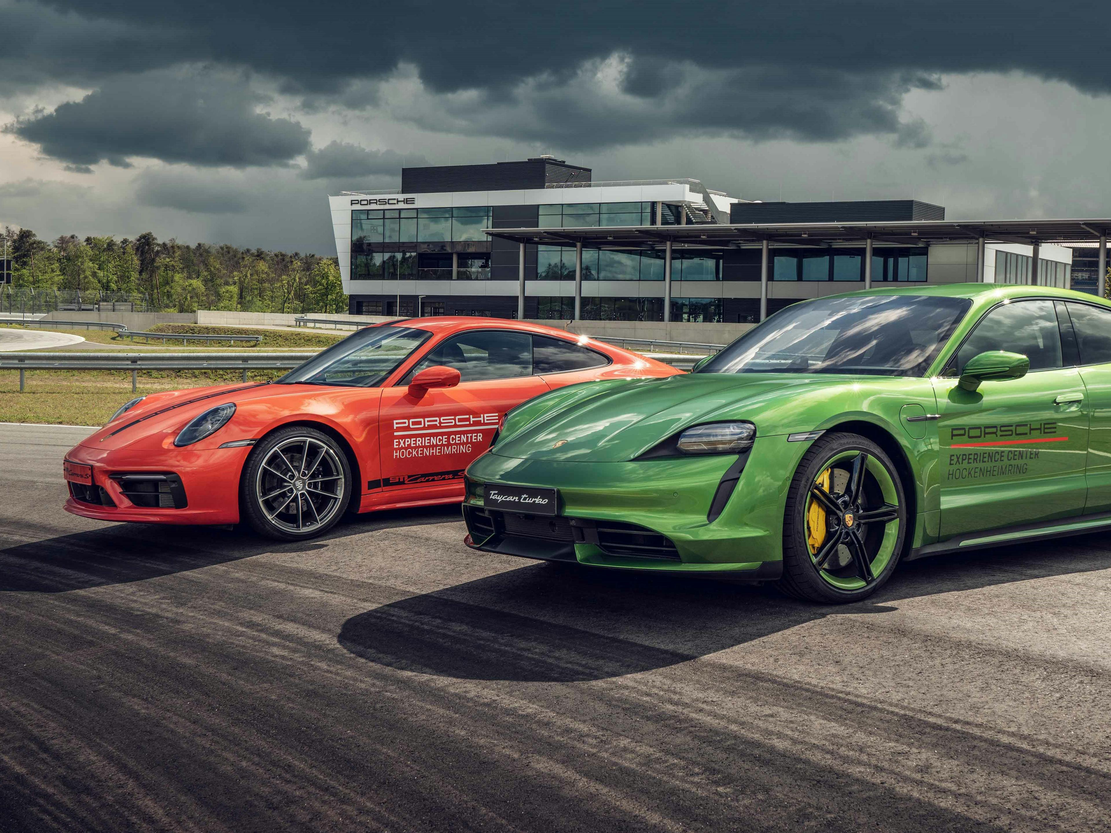 Dos modelos Porsche se encuentran uno al lado del otro en una zona de prácticas en el Porsche Experience Center de Hockenheimring.