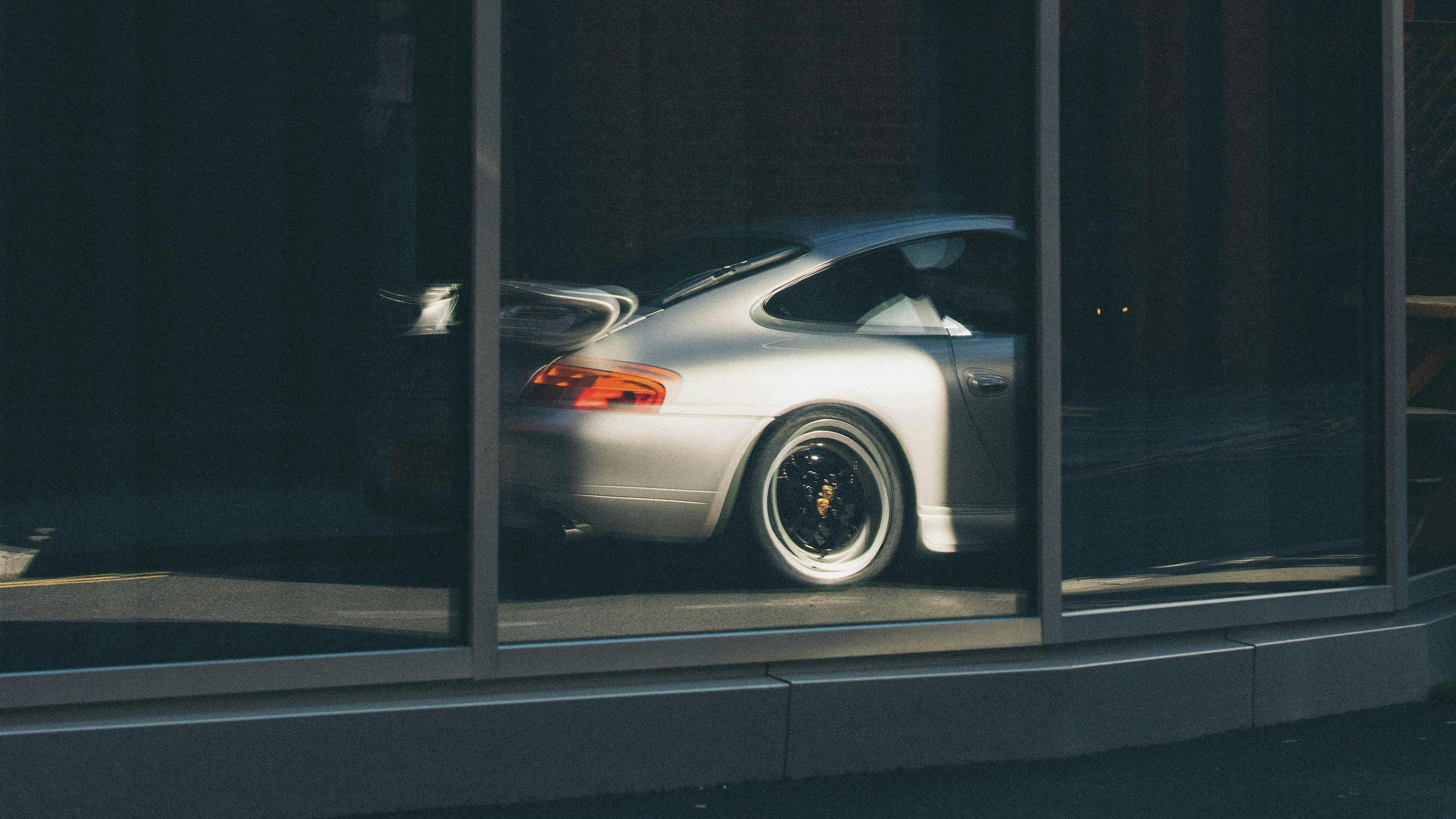 Reflektion eines Porsche mit Fuchsfelgen.