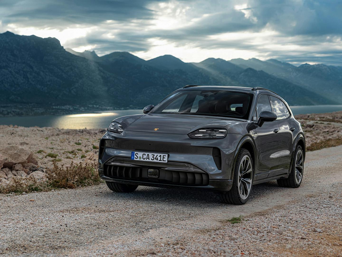 Porsche Cayenne Electric σταθμευμένη σε φυσικό τοπίο με βουνά και λίμνη (στατική σε φυσικό τοπίο)
