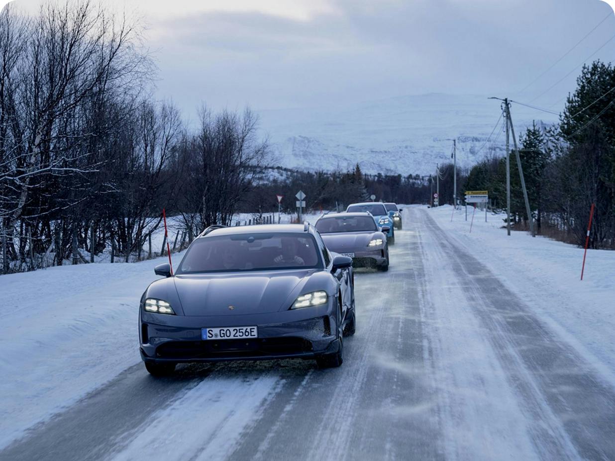 Vários modelos Porsche a circular numa estrada gelada na Noruega. Vista dos veículos a partir da frente.