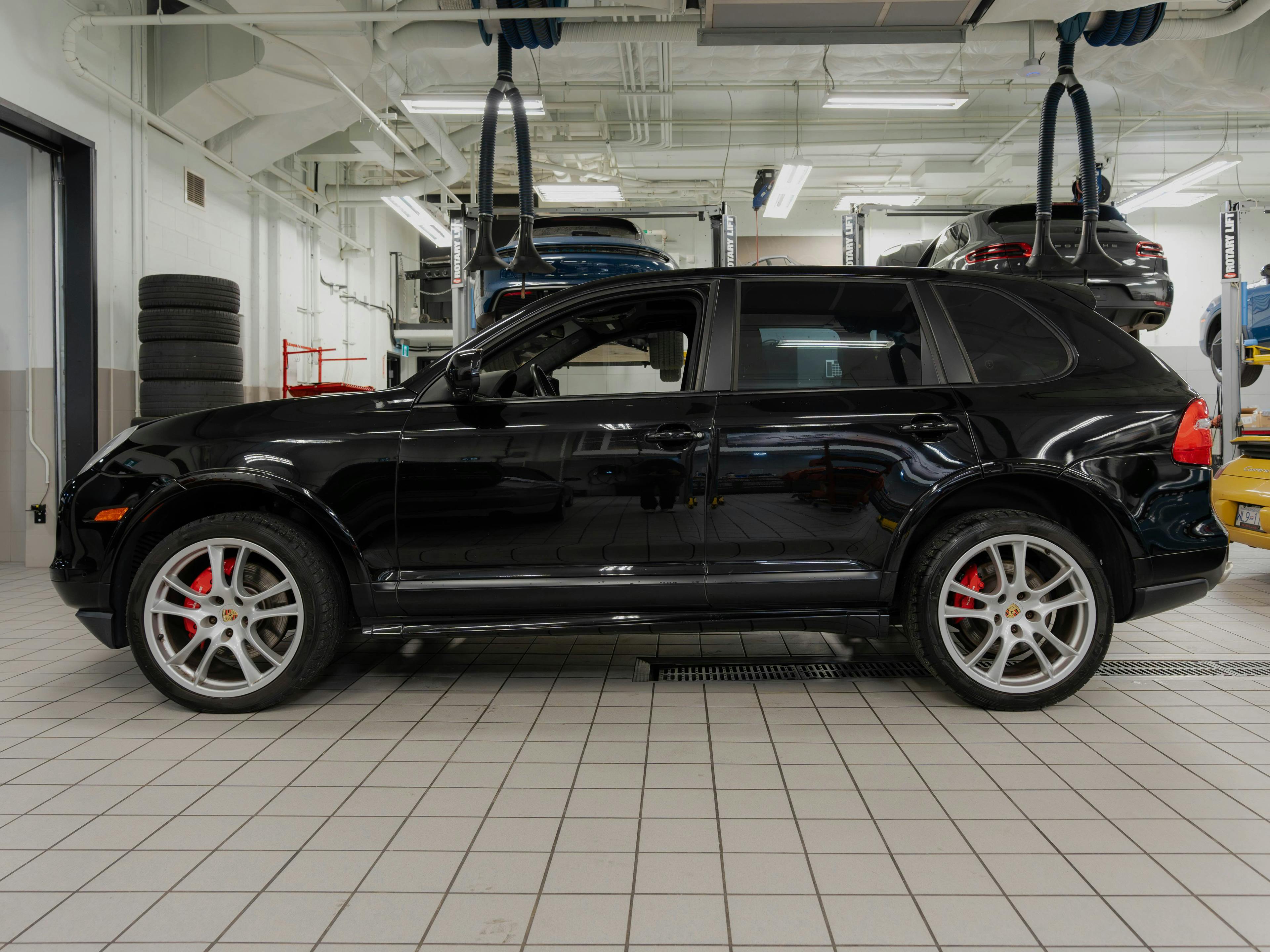 Victoria – A black Porsche Cayenne pictured from the side in a workshop.