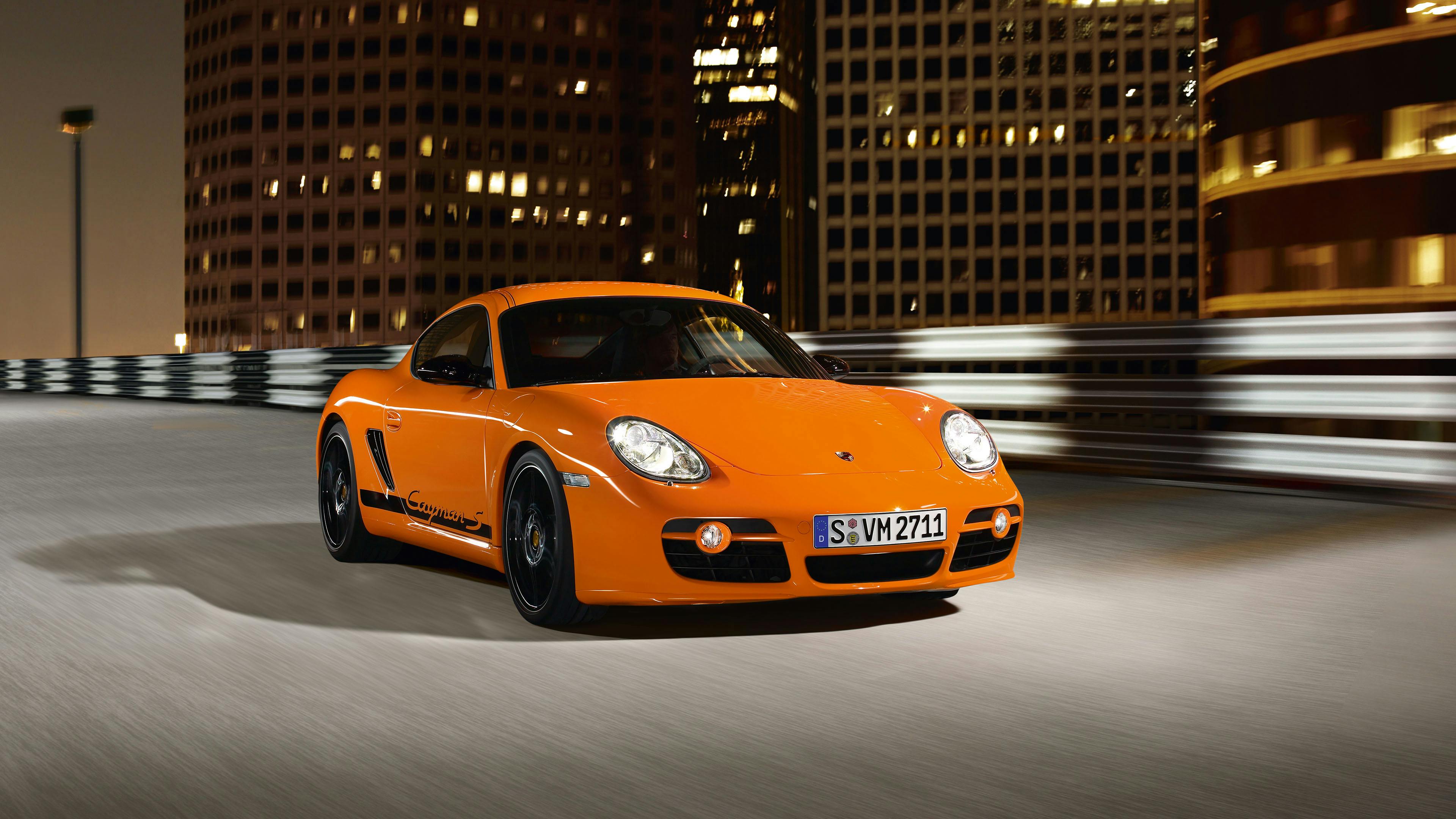 Cayman S Sport de color Naranja circulando por un entorno urbano.