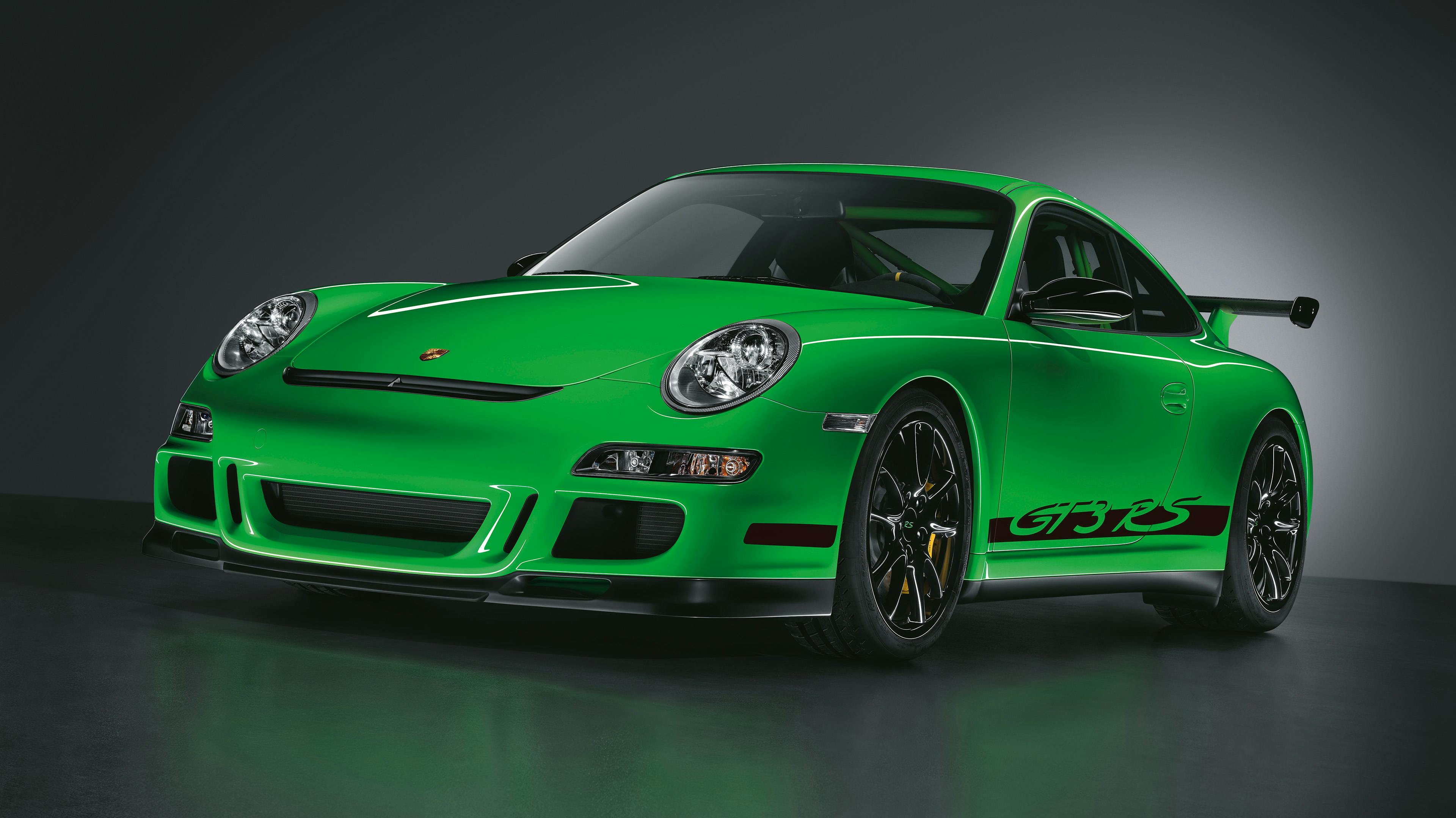 Studio shot of a green 997 911 GT3 RS on a black background.