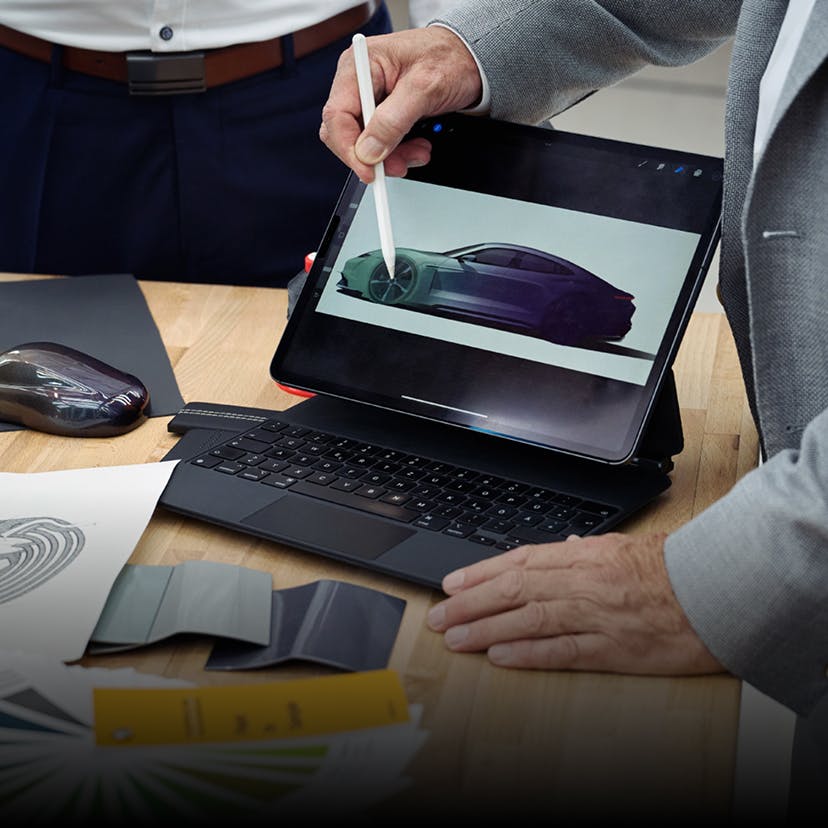 Adviesgesprek met Porsche Sonderwunsch met schets op tablet.