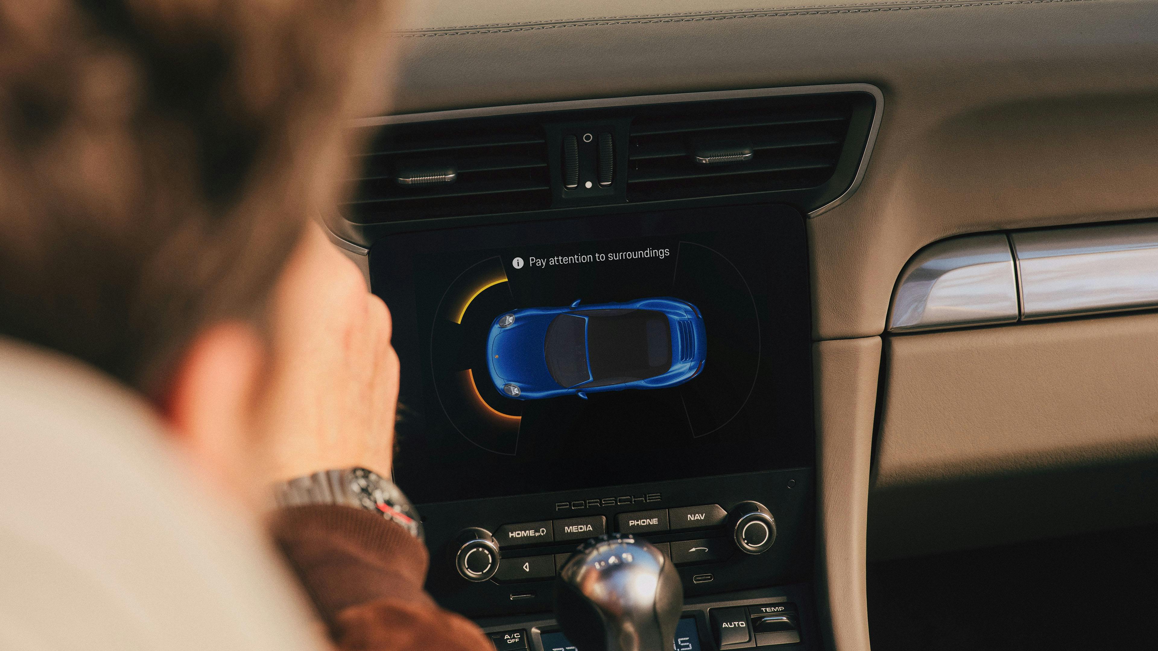PCCM Plus Display zeigt den Parkassistenten mit digitaler Fahrzeugdarstellung eines blauen Porsche 911 (Typ 991 I)