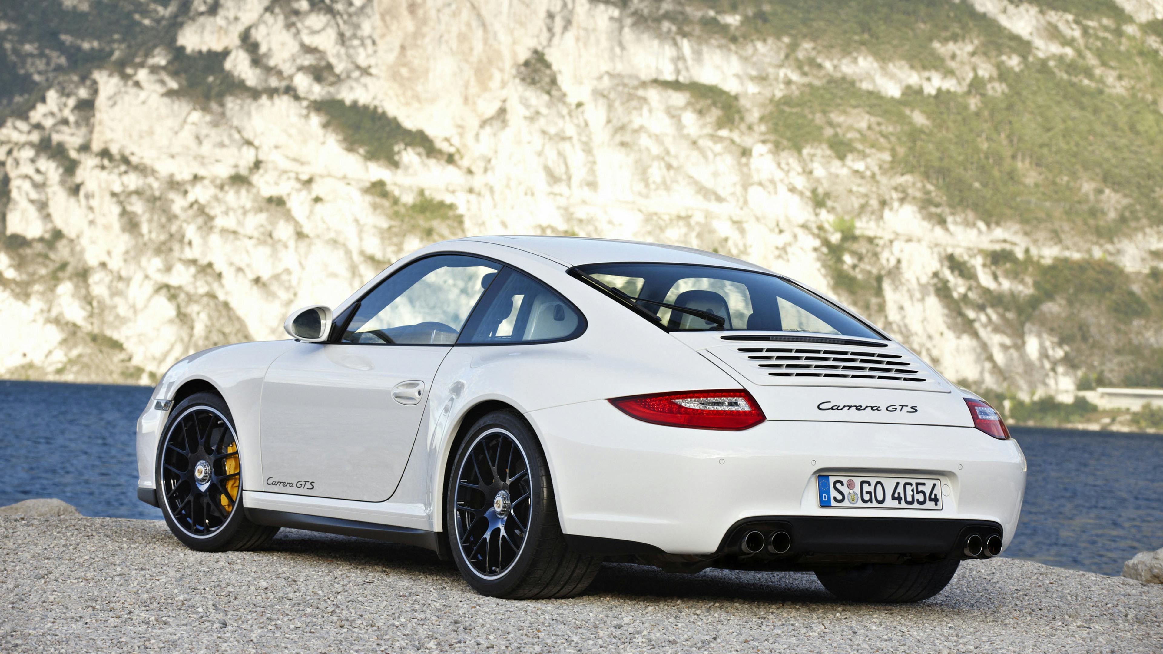Parked white 911 Carrera GTS Coupé type 997 on a lakeshore