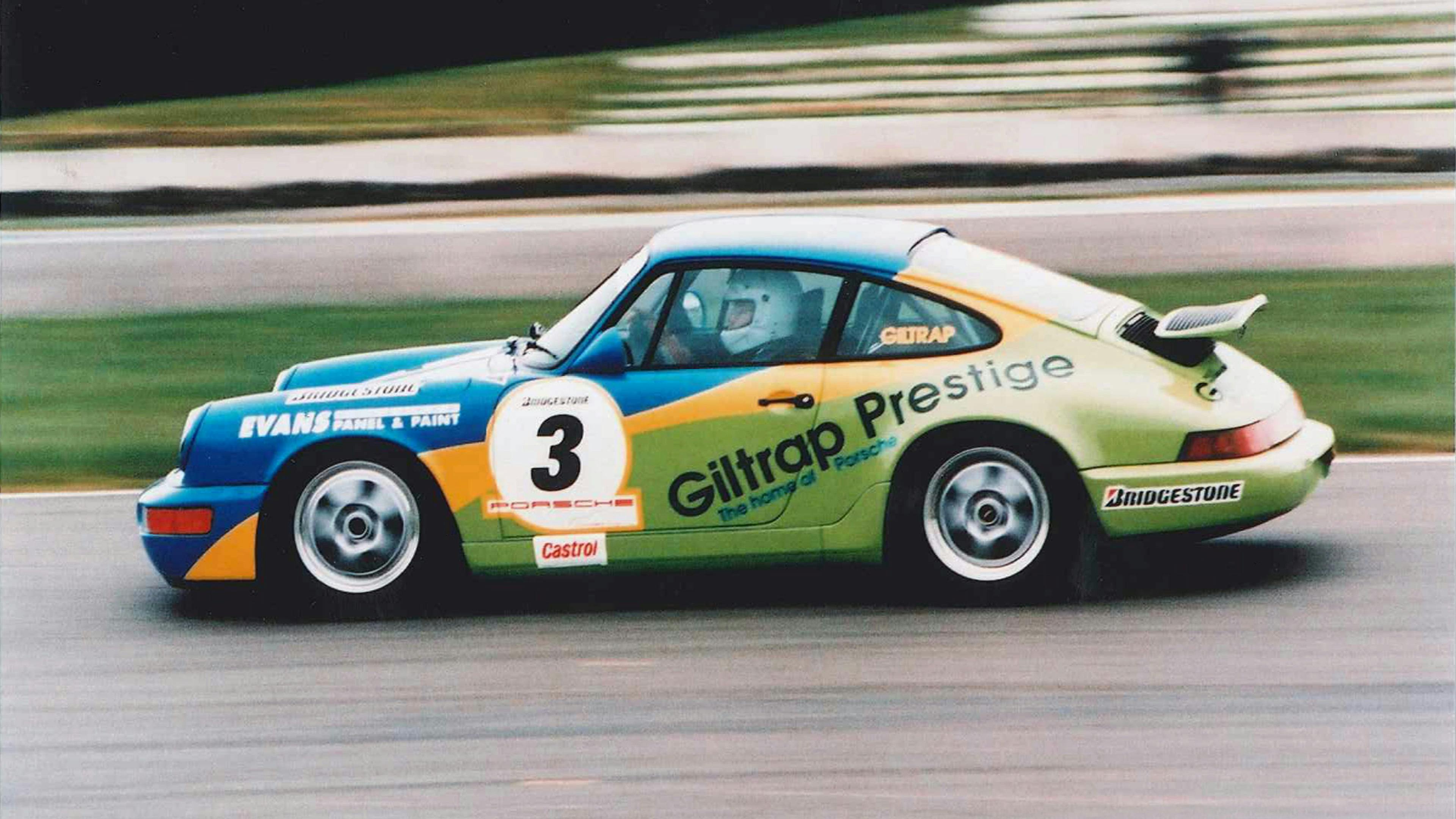 Colourful Porsche race car on a race track.