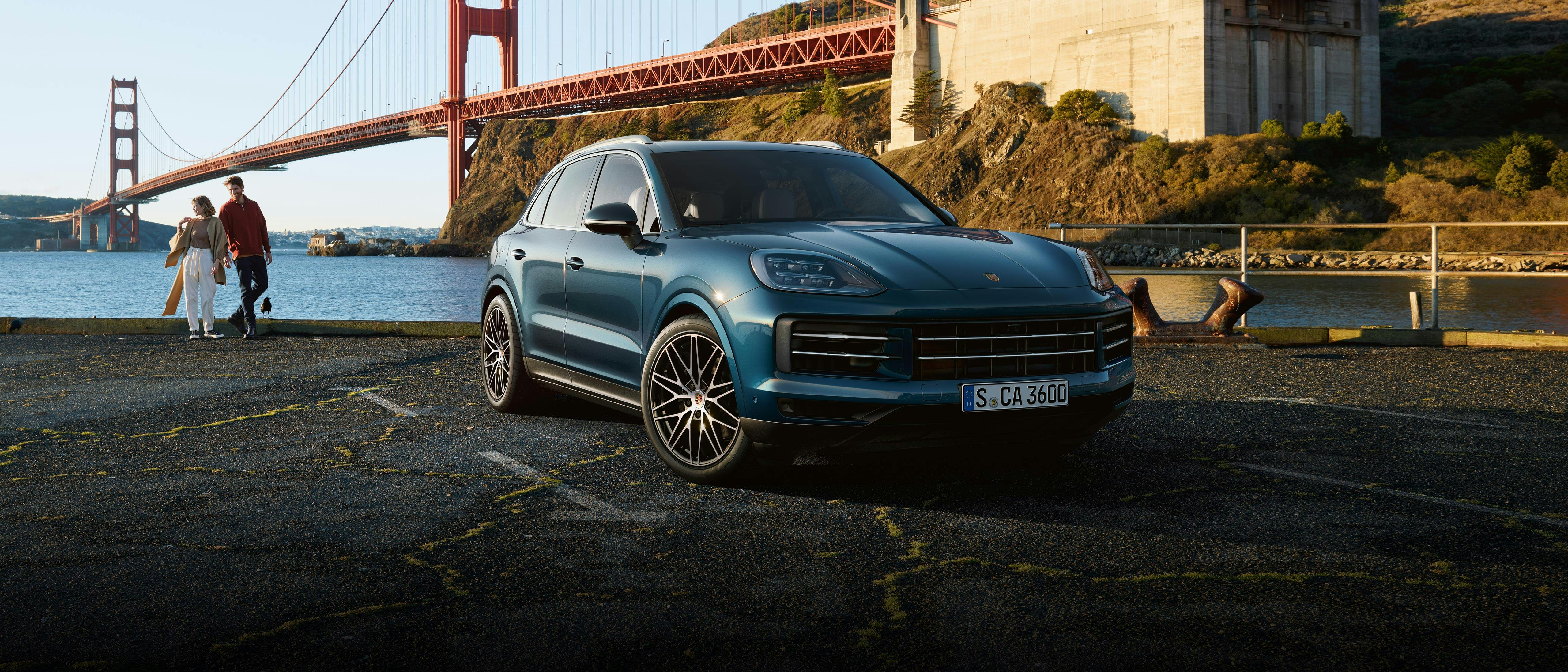Porsche Cayenne en color Azul con un puente detrás.