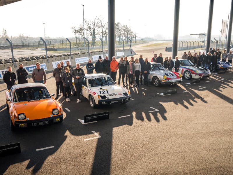 Les équipes participantes se tiennent derrière leurs véhicules au Porsche Experience Center Le Mans.