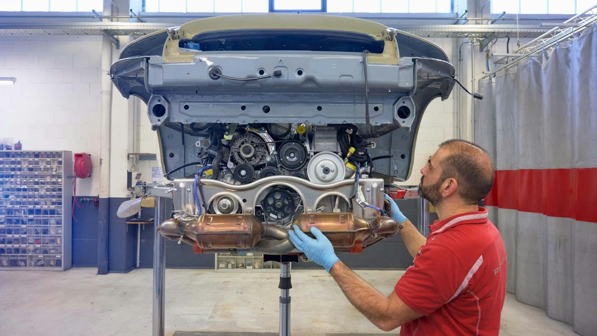 Workshop scene: engine is fitted into Porsche bodyshell