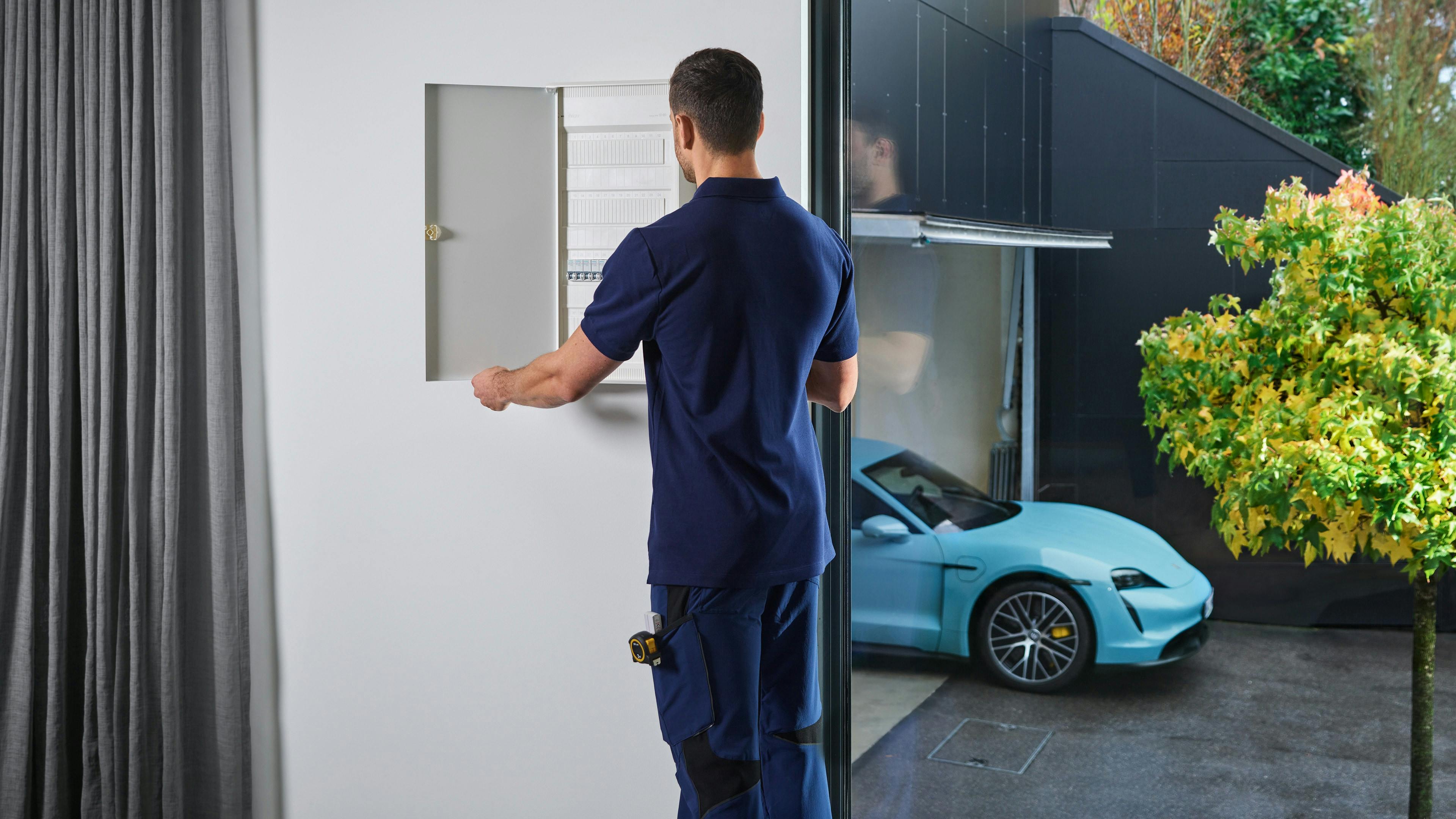 Eine Elektrofachkraft überprüft die Ladeinfrastruktur bei einem Porsche Kunden.