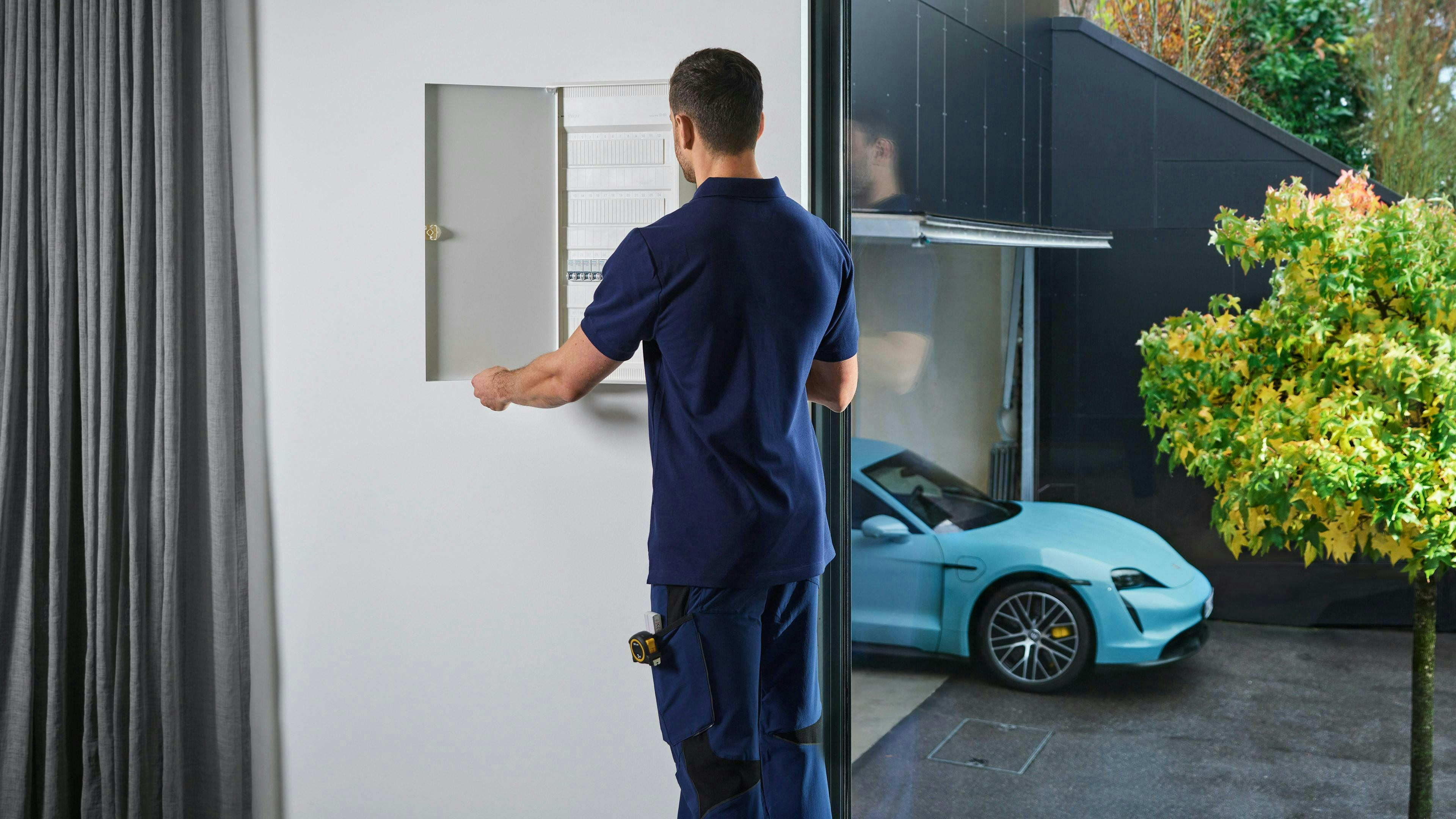 An electrician checking the charging infrastructure at the home of a Porsche customer.