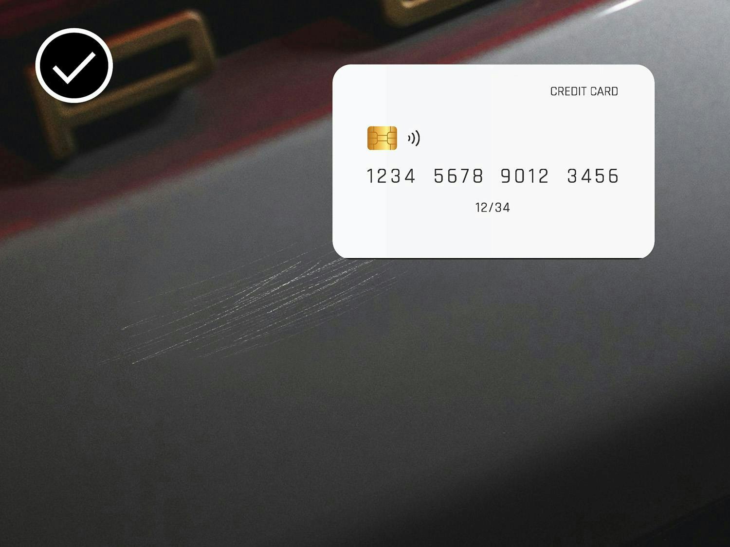 Credit card on a smooth red surface with a checkmark indicating acceptable scratches.
