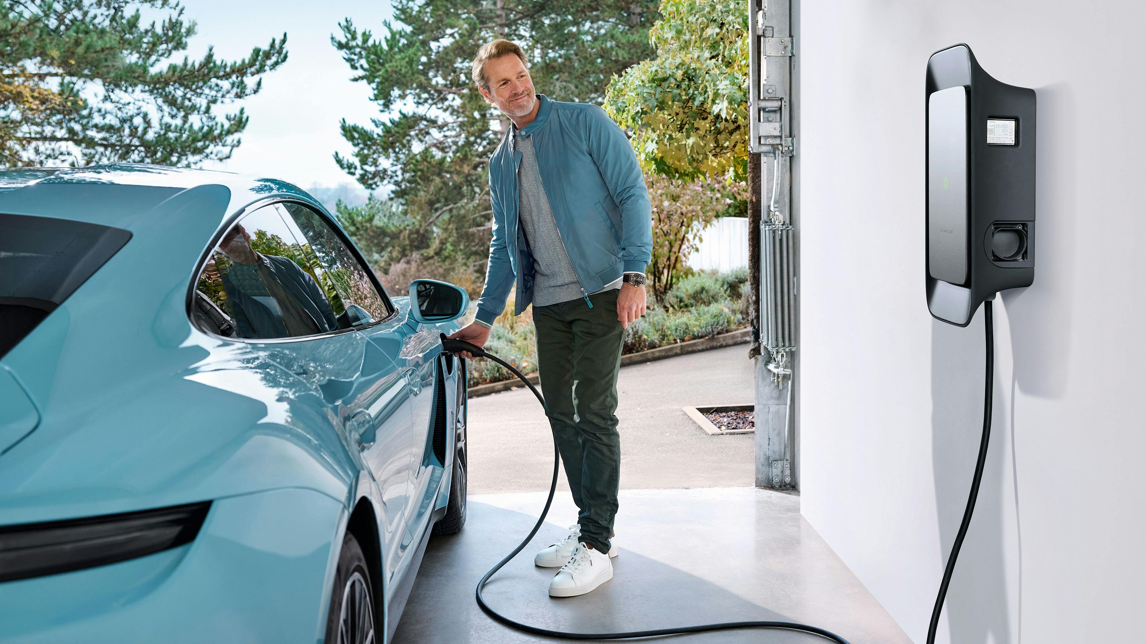 A customer charging their Porsche in their own garage with the Porsche charging hardware.