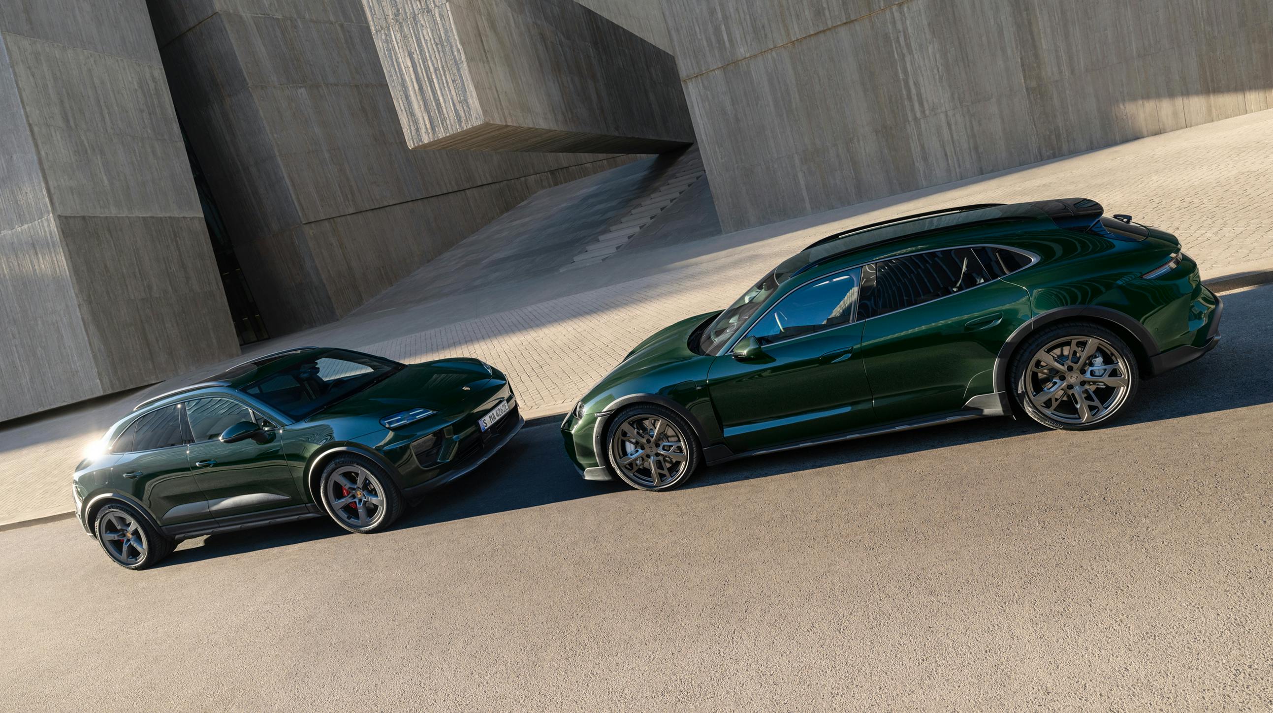 A Porsche Macan 4S and a Porsche Taycan Turbo Cross Turismo facing each other in front of a concrete structure.