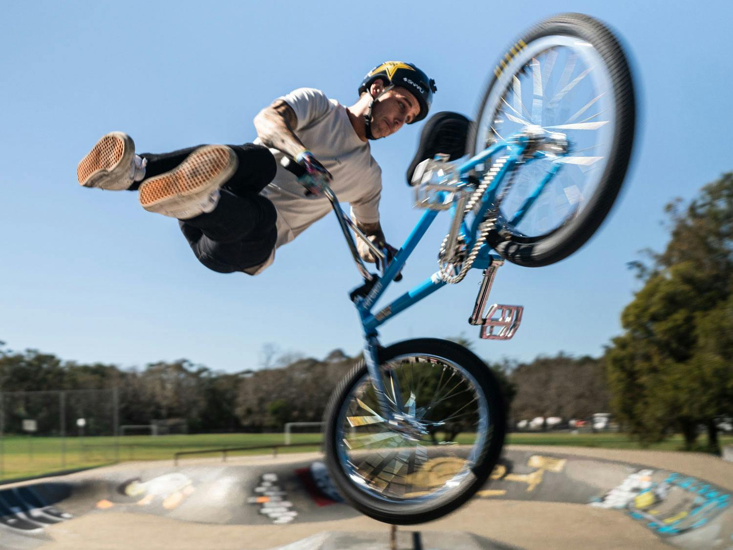 Logan Martin mid-air doing a BMX trick at a skatepark