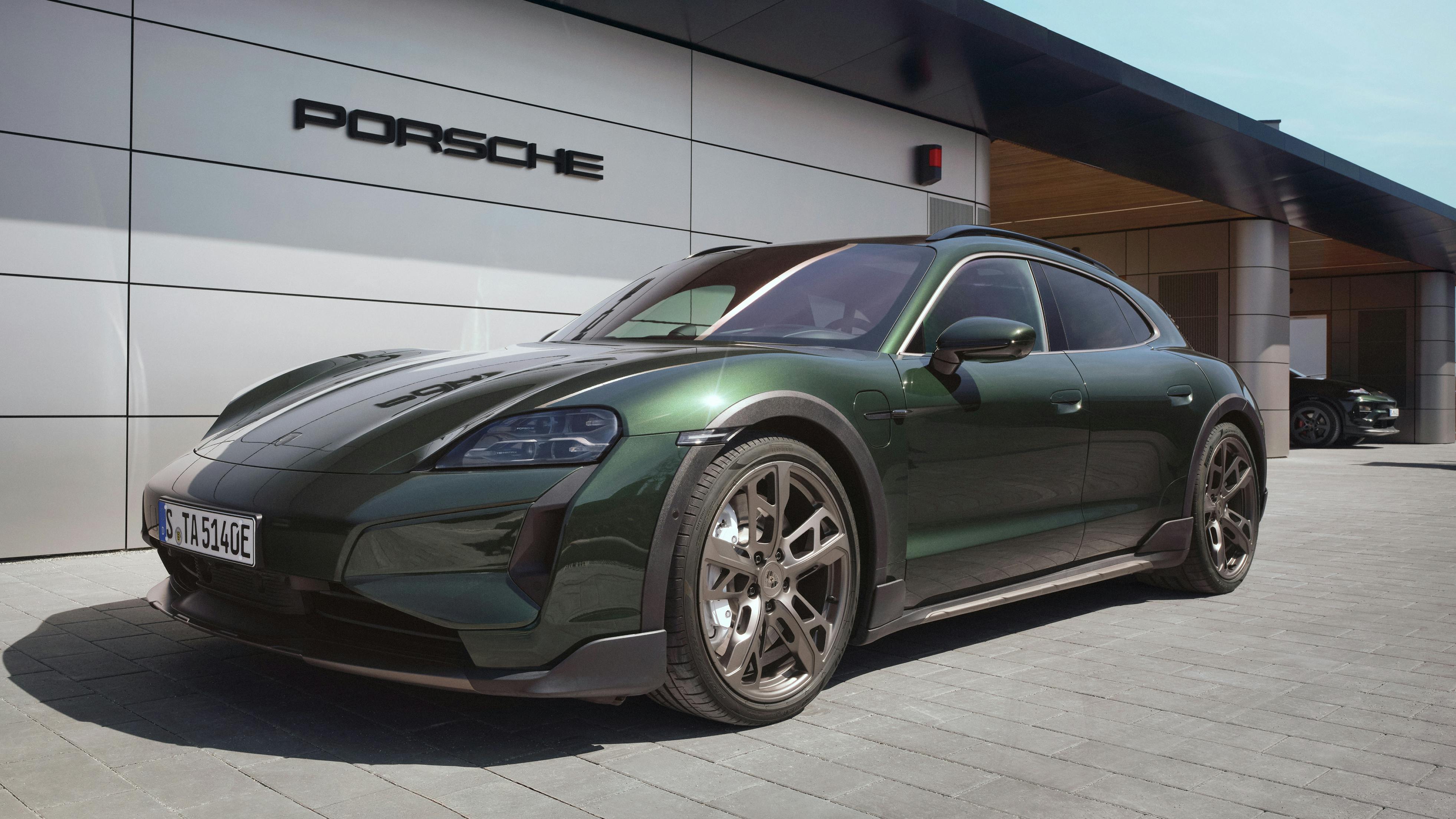 A Porsche Taycan Turbo Cross Turismo in front of a Porsche Charging Lounge.
