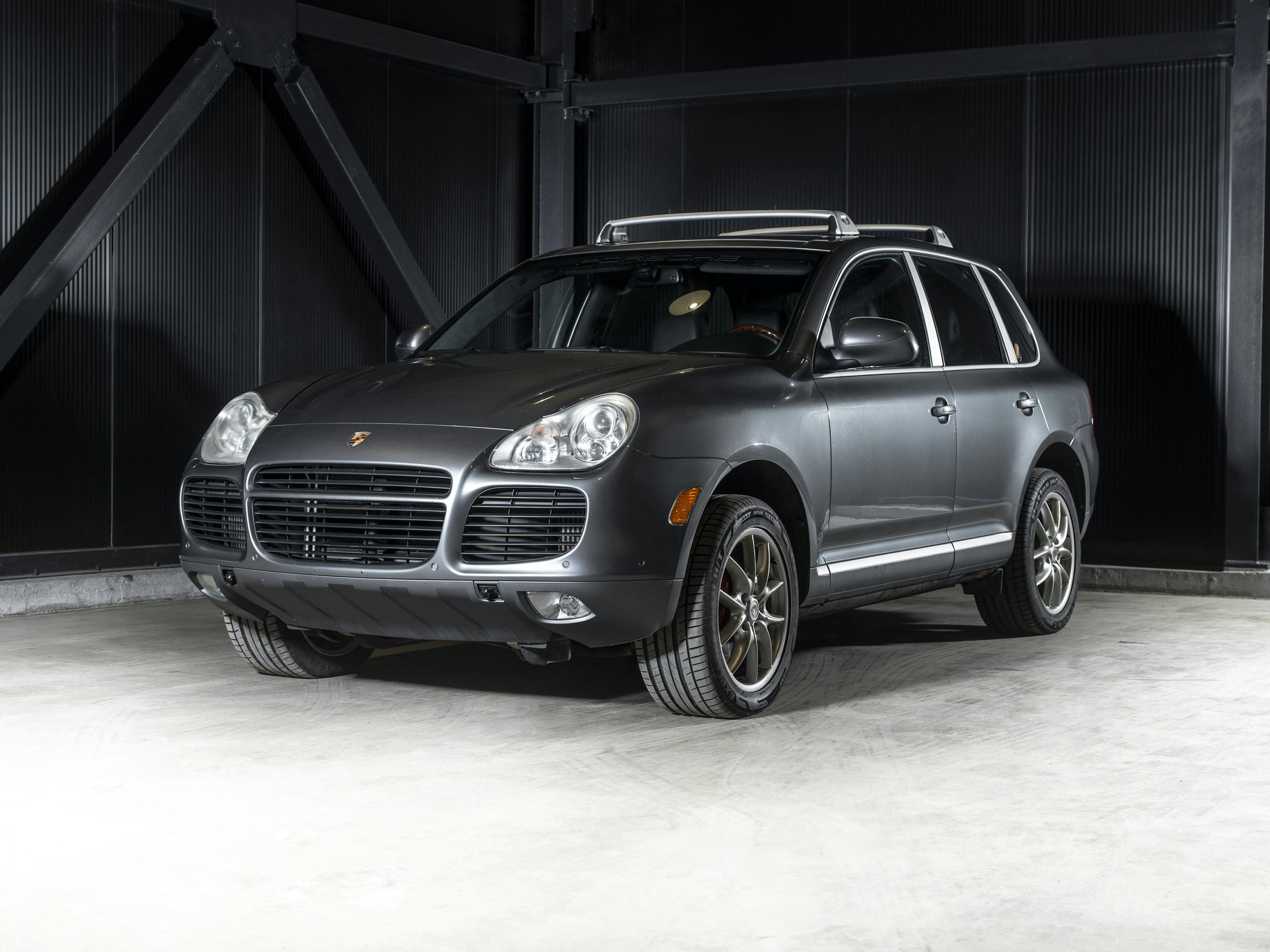 Quebec – A grey Porsche Cayenne displayed in an industrial setting with metallic walls.