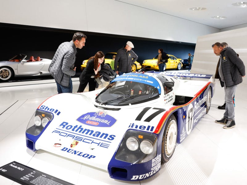 Les finalistes du Concours de Restauration regardent une voiture de course au musée Porsche de Zuffenhausen.