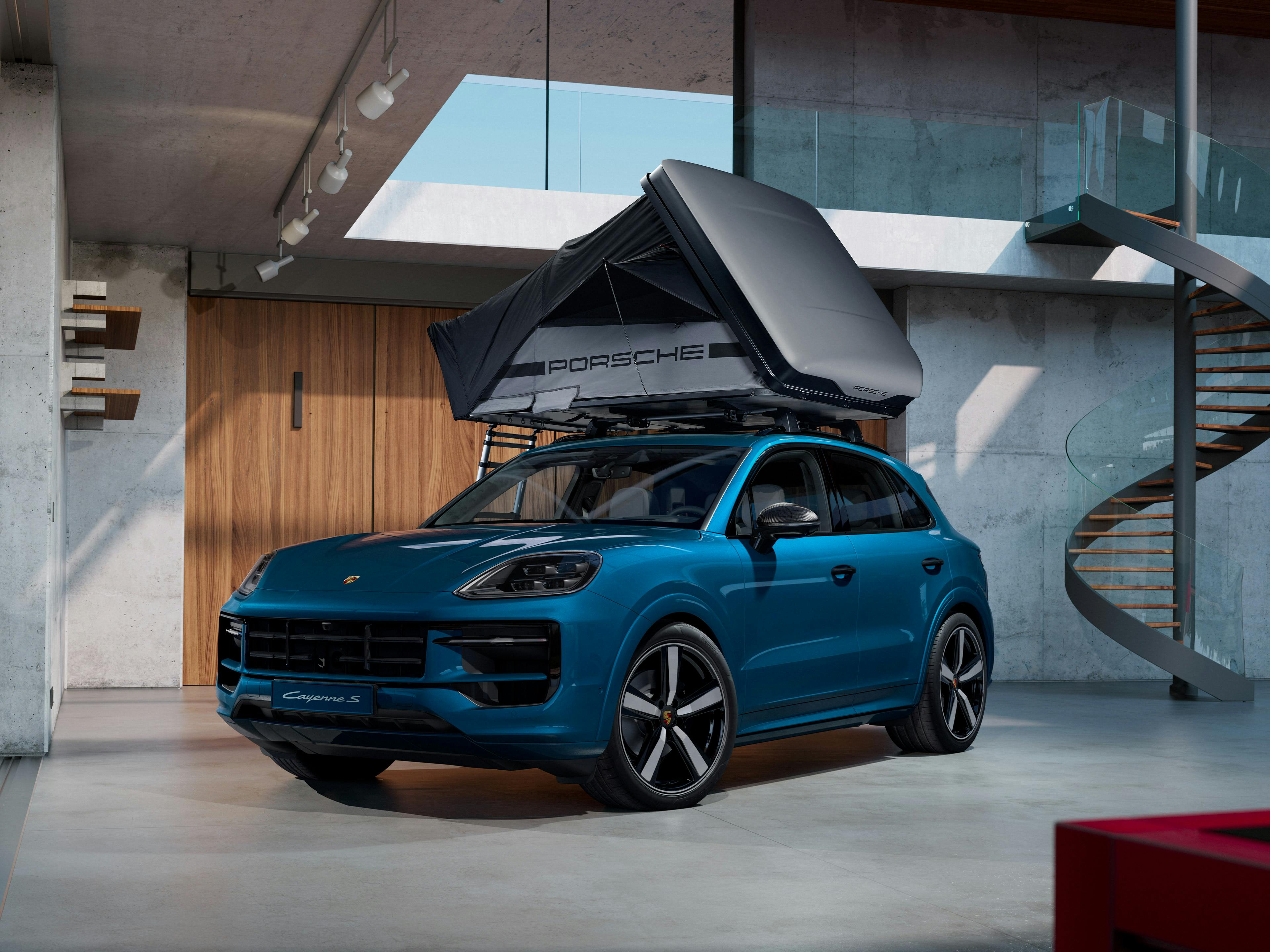 Une tente de toit est installée sur un Cayenne dans un garage.
