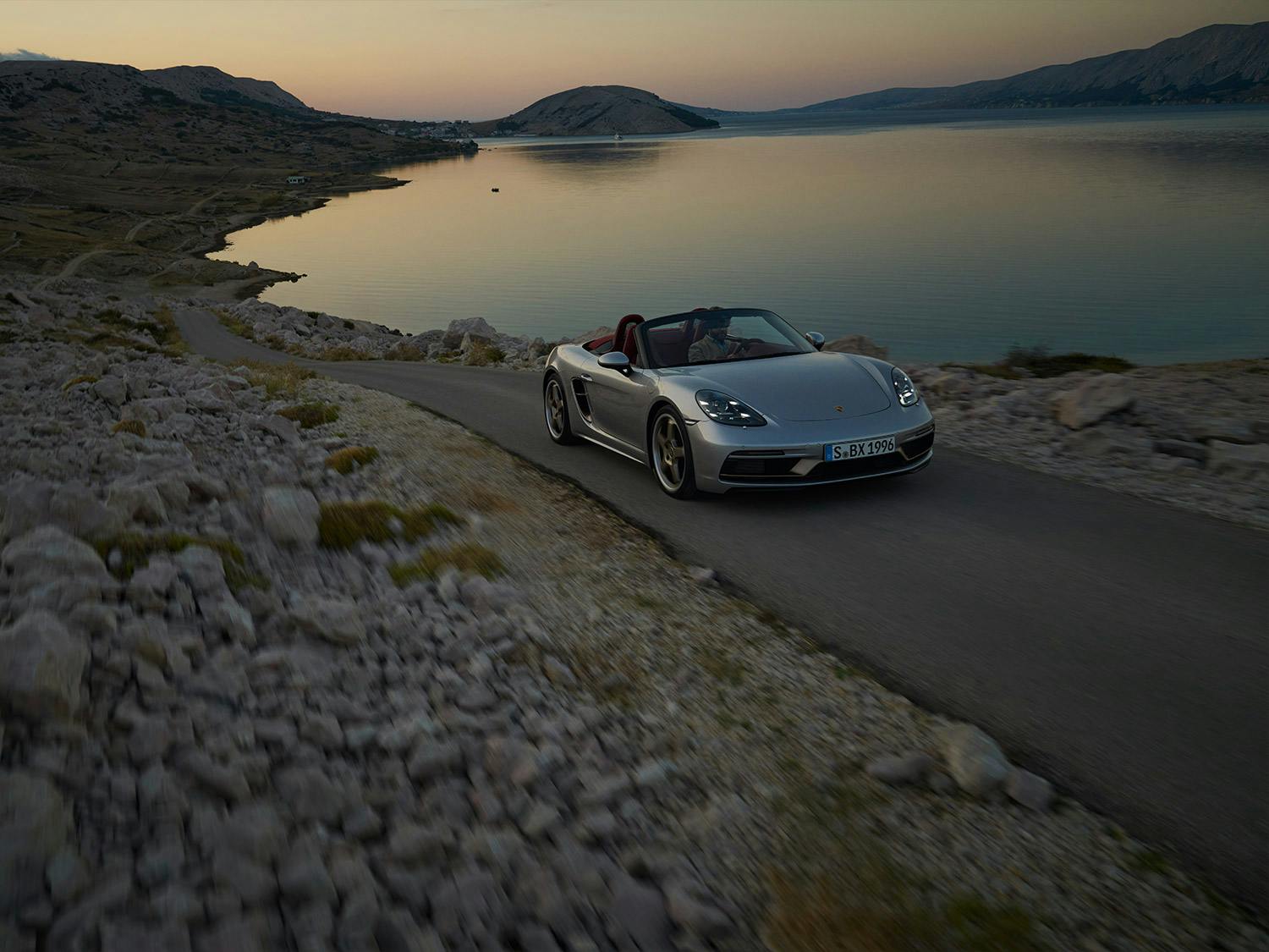 Une Porsche Boxter 25 ans, sur les bords d'un lac.