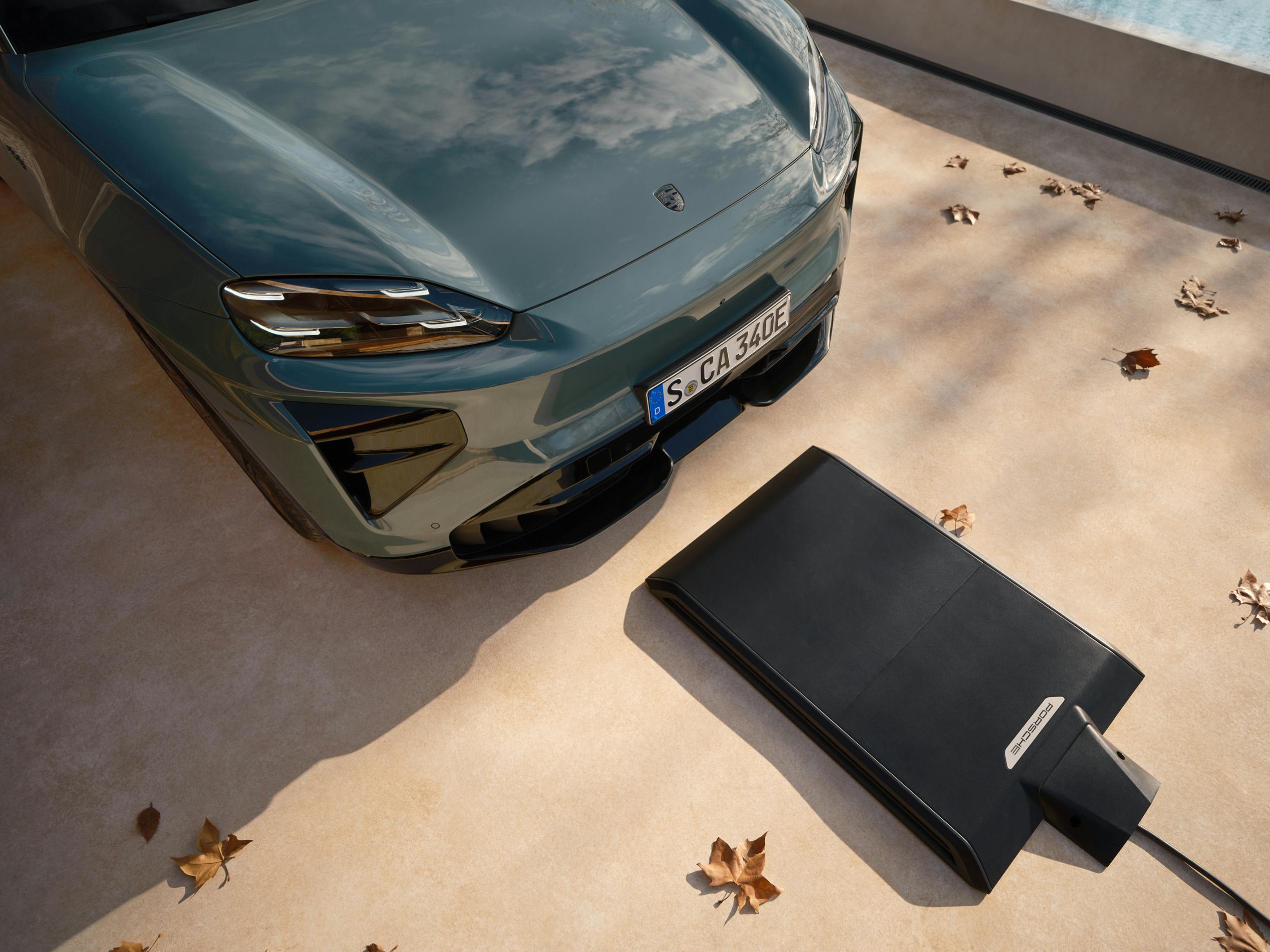 Un Porsche Cayenne Electric delante de una plataforma de carga del sistema Porsche Wireless Charging.