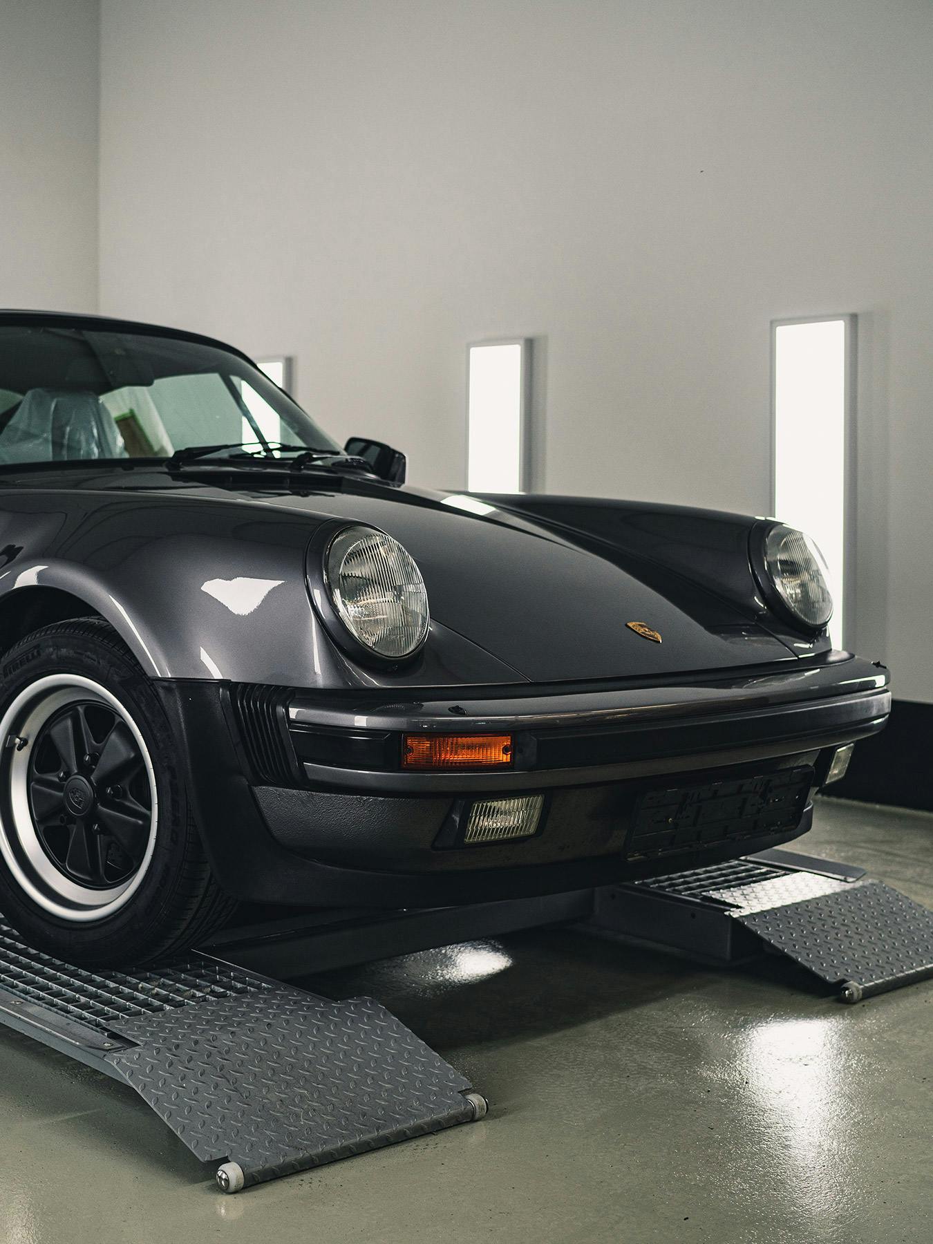 The covers being taken off of a classic Porsche 911.