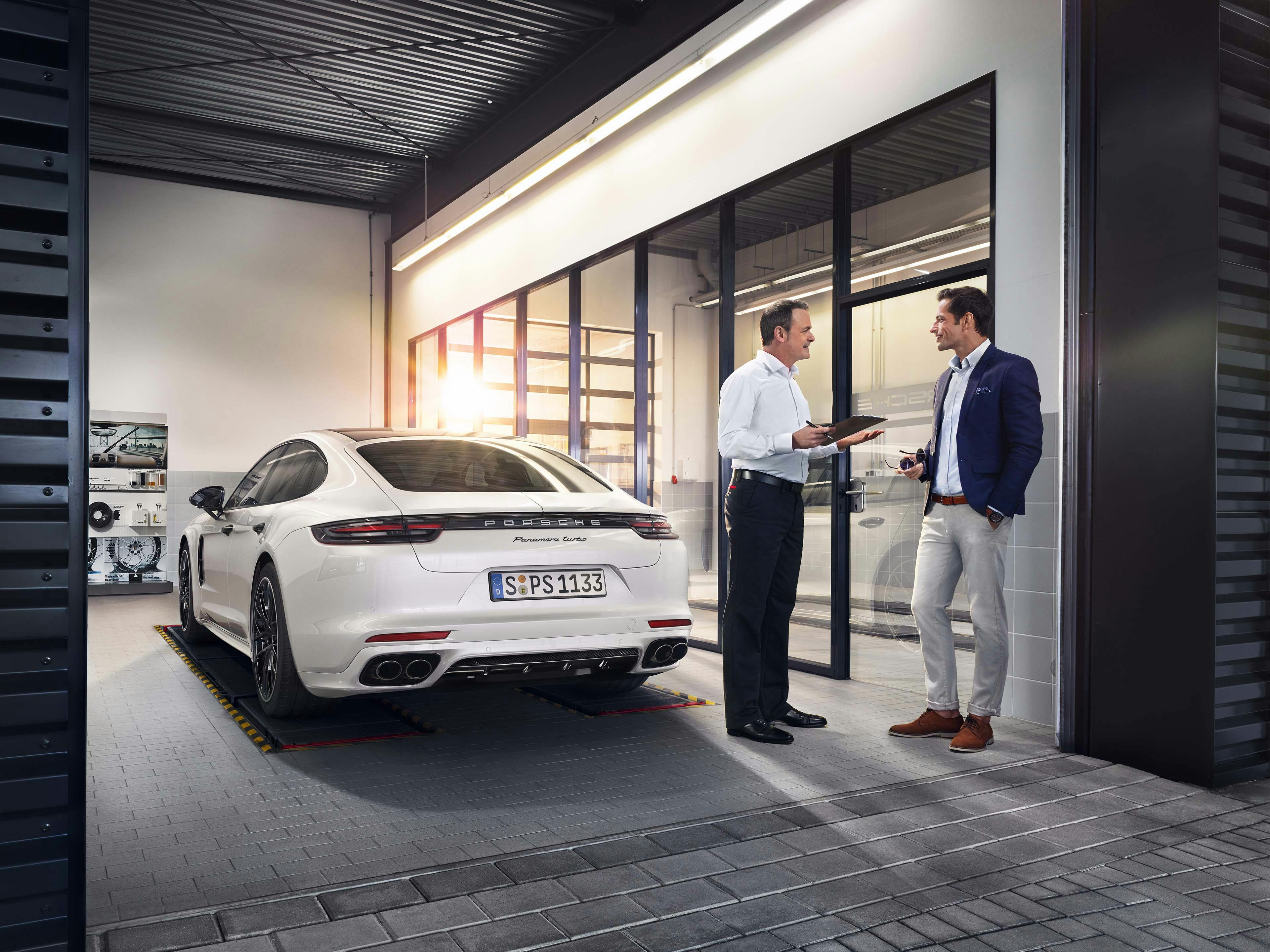 Mannen bespreken garantie in Porsche werkplaats