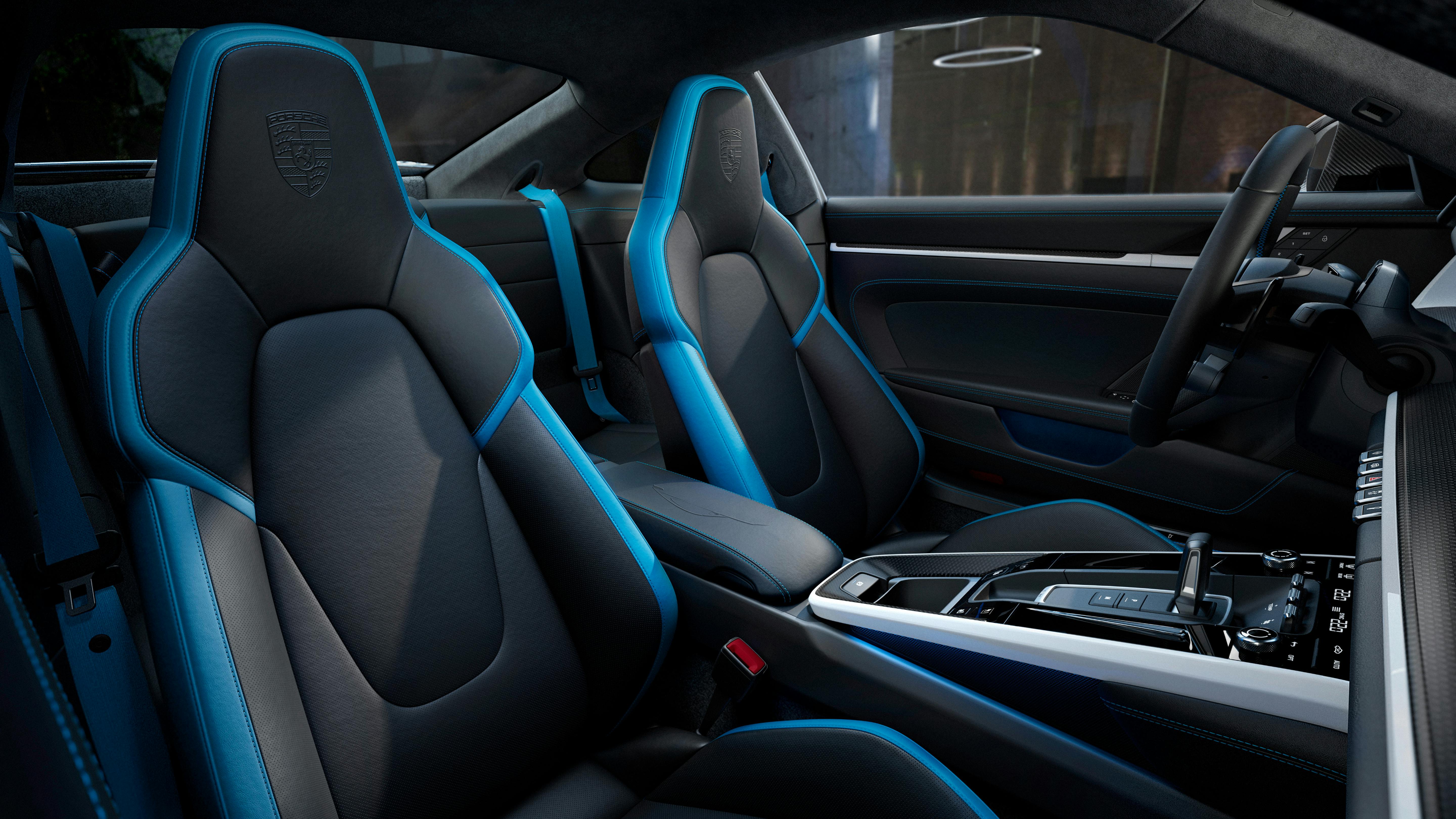 Vista del puesto de conducción del 911 Carrera GTS de Porsche Exclusive Manufaktur con interior de cuero en color Negro, con detalles en los asientos y costuras decorativas en color Azul Arctic.