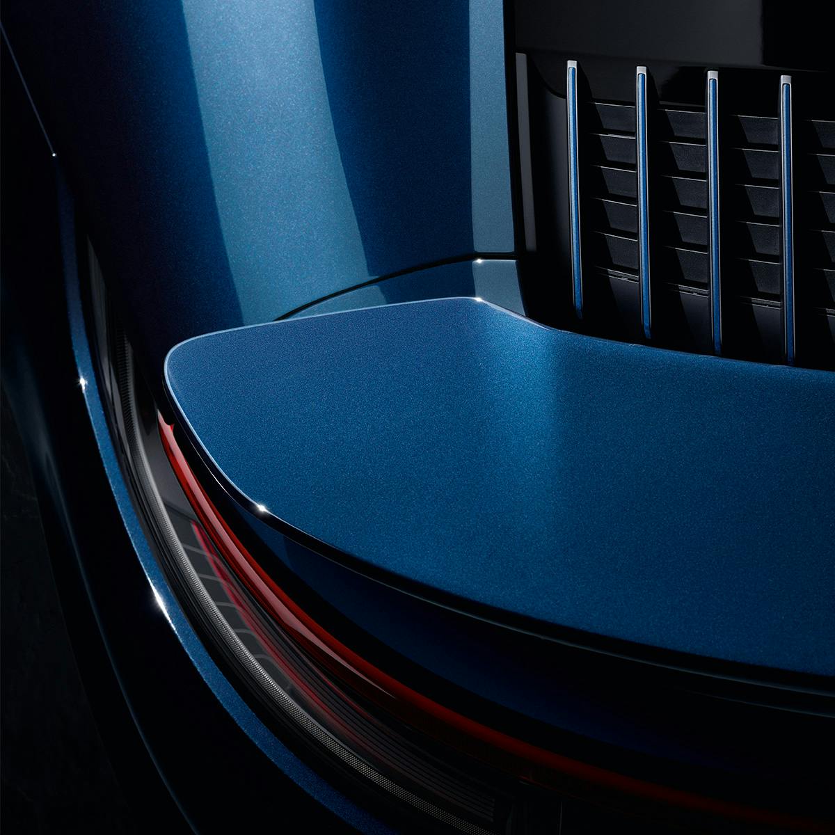 Close-up of a blue Porsche car's sleek design, showcasing a glossy surface with red accents and grille details in modern, aerodynamic styling.