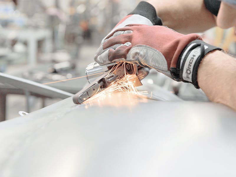 Detail shot: processing the weld seam, gloved hands