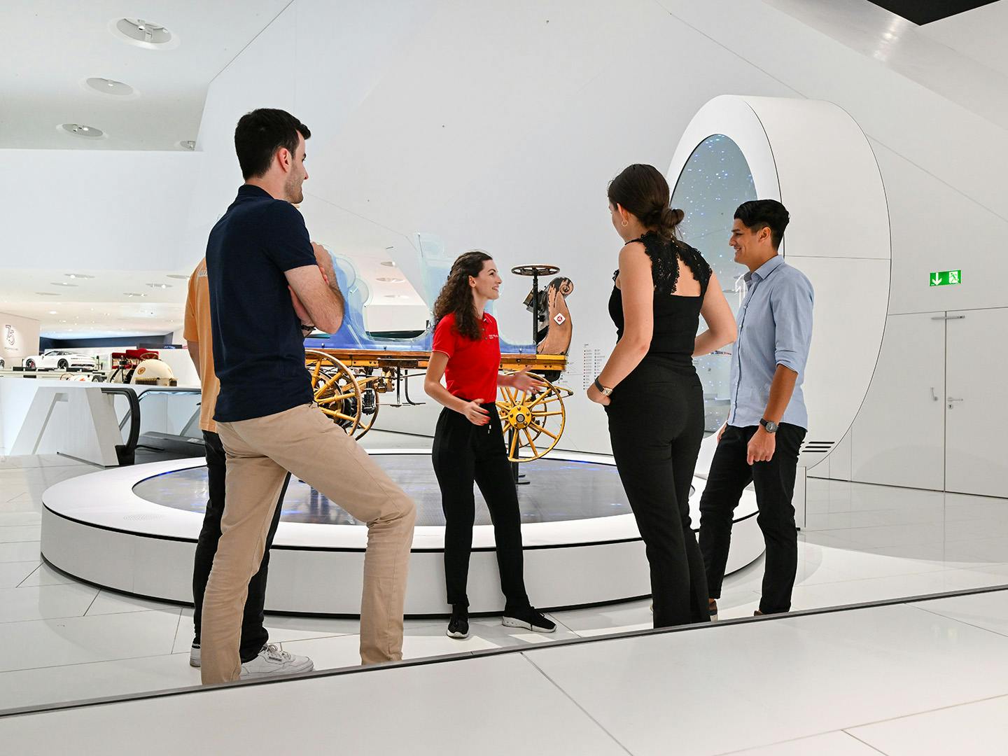 A group of pupils is given an explanation of the museum exhibition by a member of staff.