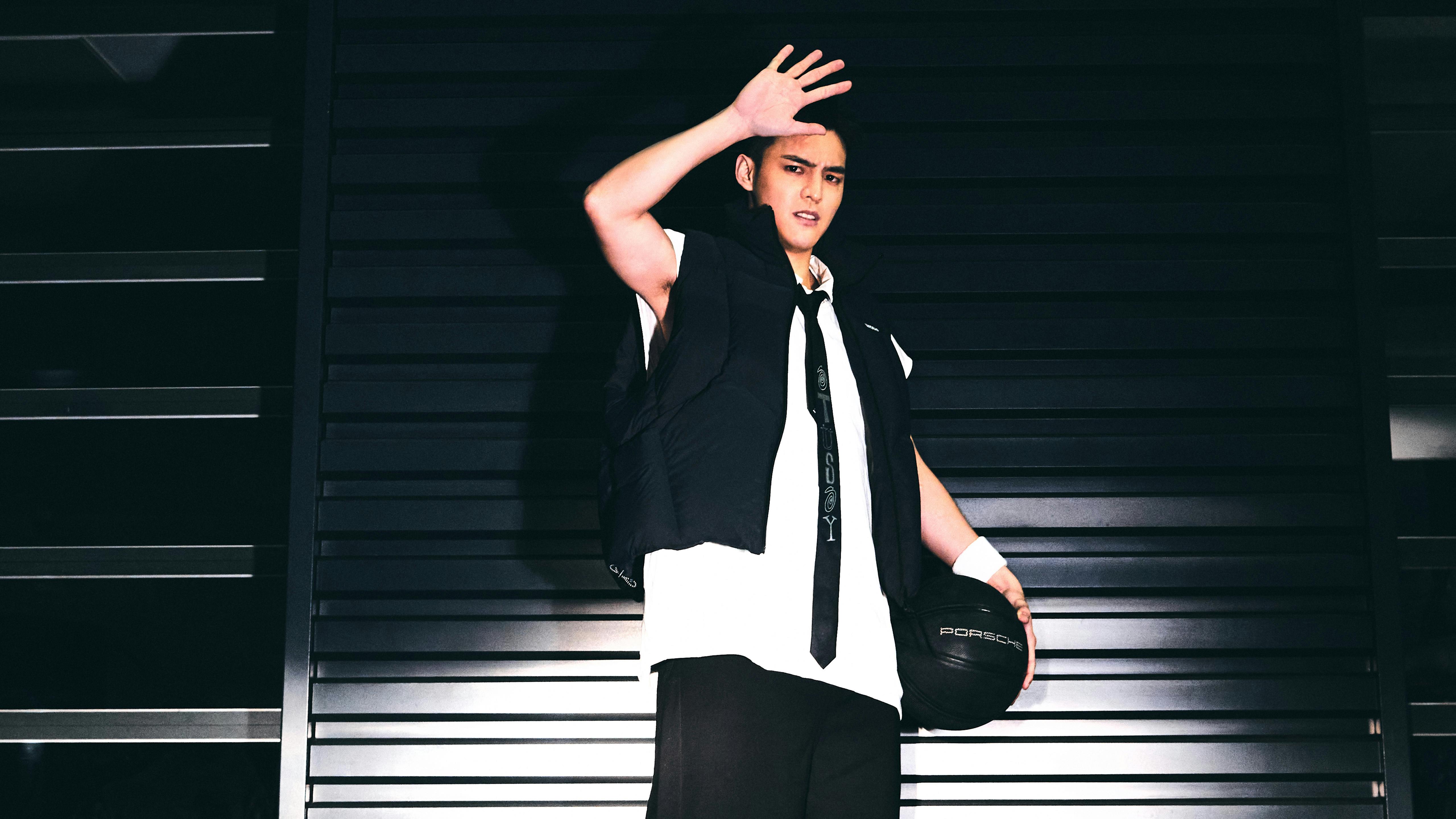 Lin Chun-Chi holding a ball in front of the camera and shielding his eyes.
