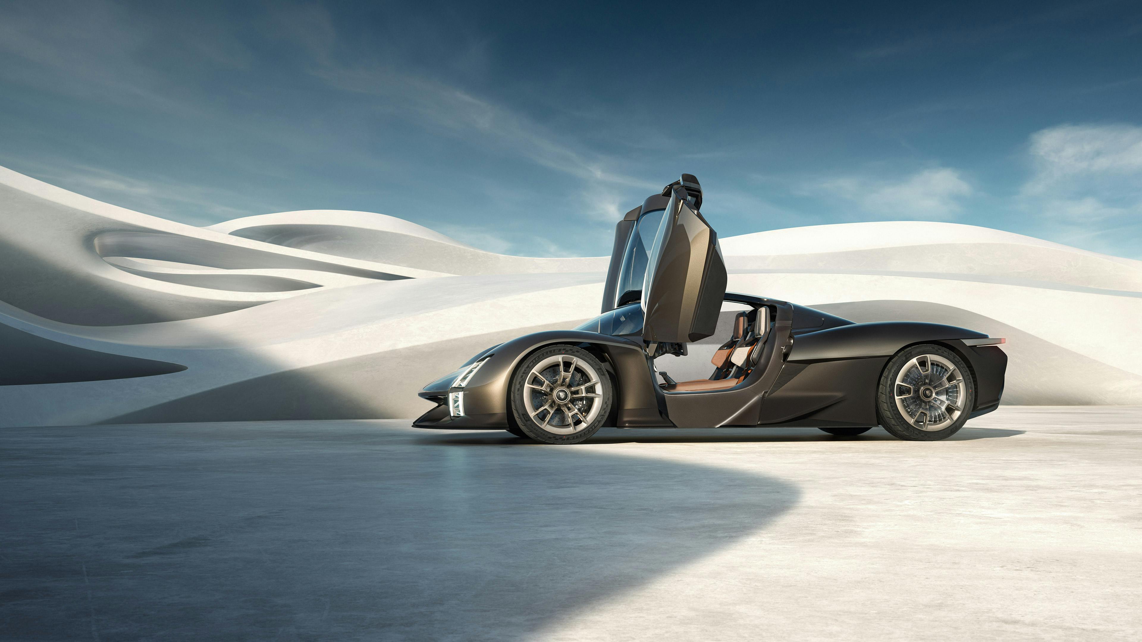 La Porsche Mission X in Rocket Metallic con le portiere Le Mans aperte davanti a un edificio ondulato. Vista laterale.