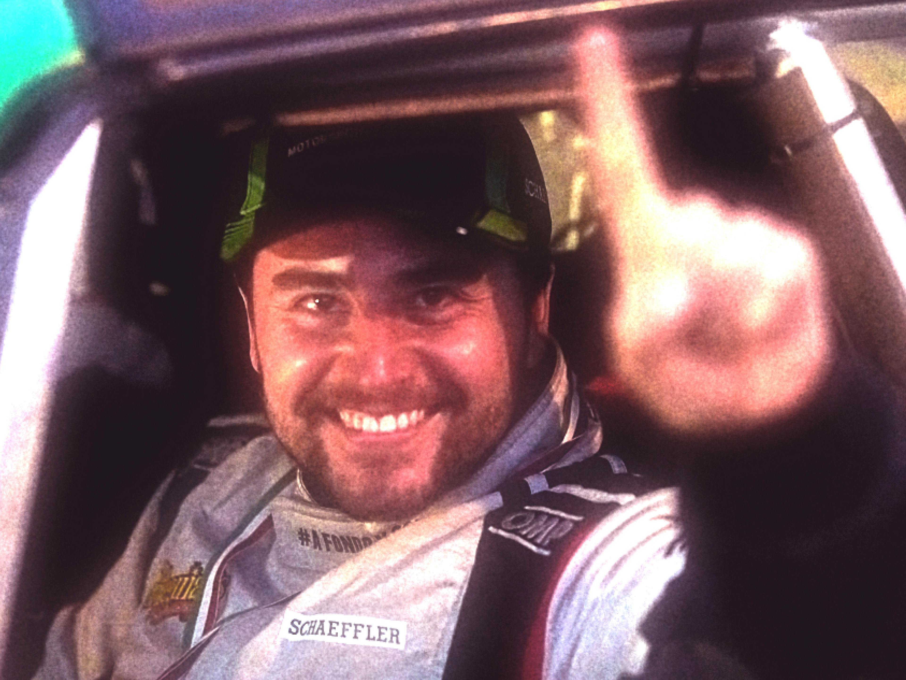 Fercho Urquiza hace un gesto de celebración desde el asiento del conductor de su auto de carreras.